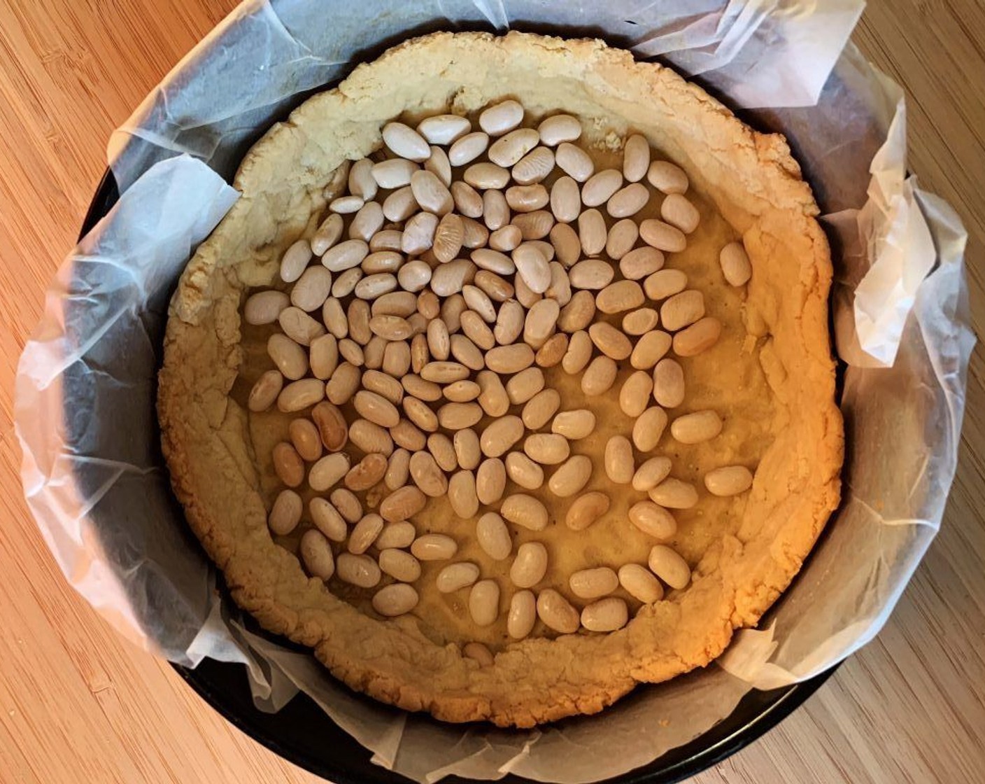 step 6 Lay the dough into a pie pan. Cover it with beans or pie weights and cook it in preheated oven for 30 to 40 minutes. Remove from the oven and let it cool down completely.