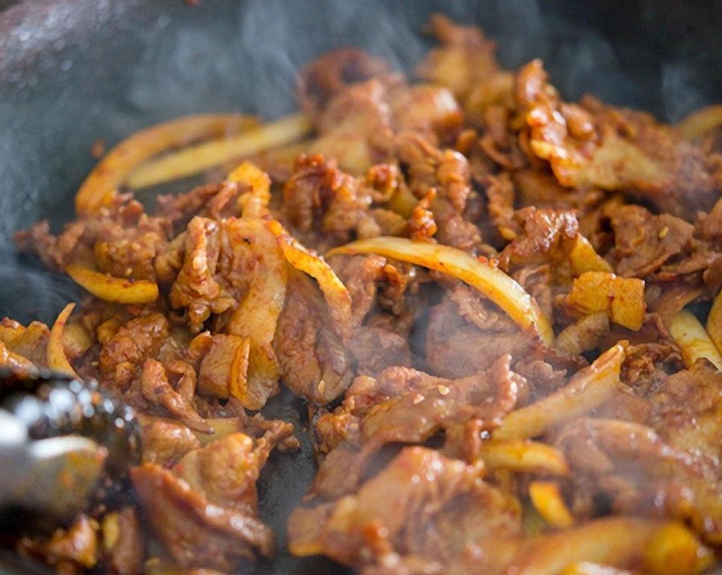 step 9 When they sizzle, start tossing everything to cook evenly all the way or until the pork is fully cooked and onions are soft, about 3-5 minutes.