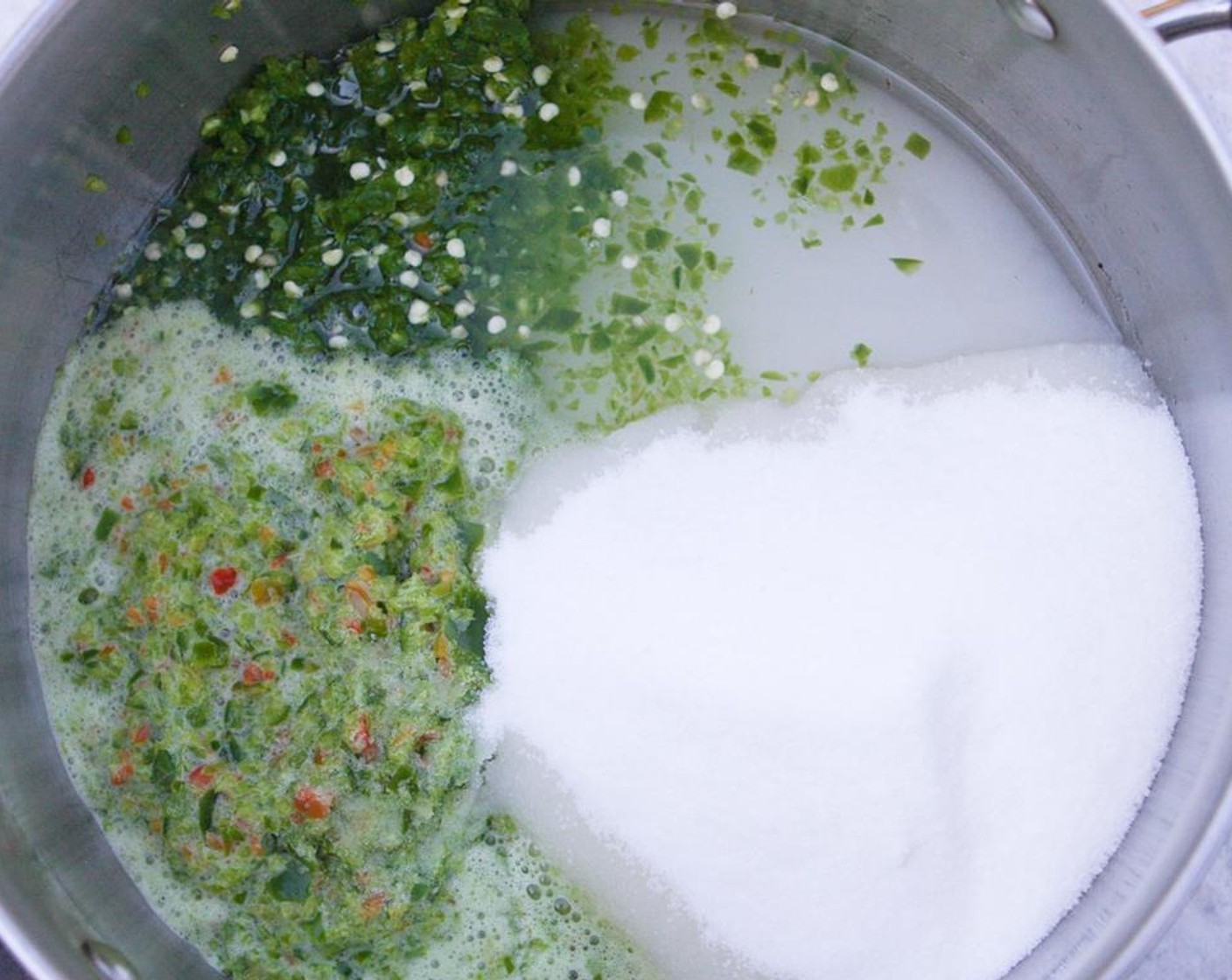 step 2 In a large saucepan, combine the green bell pepper, jalapeno pepper, Granulated Sugar (6 cups), Distilled White Vinegar (1 1/2 cups), Salt (1/2 tsp). Bring to a simmer and cook for 10 minutes, stirring occasionally.