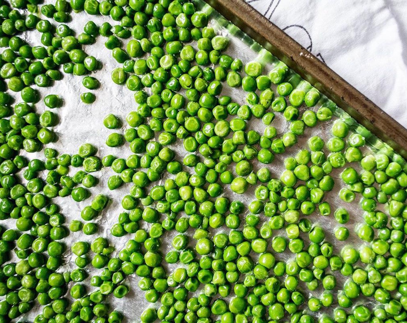 step 2 Spread Frozen Green Peas (1 bag) in single layer on large baking dish and thoroughly blot with clean paper towel to remove as much moisture as possible.