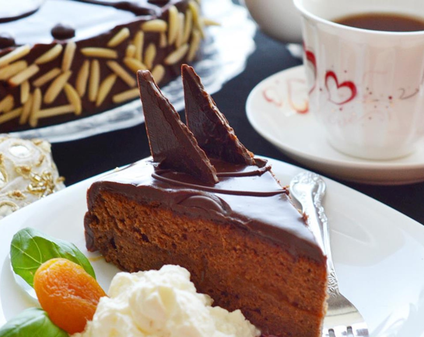 step 22 Cut the Sachertorte into wedges with a large sharp knife dipped in hot water and wipe off the blade between cuts. Serve each slice with a dollop of whipped cream.