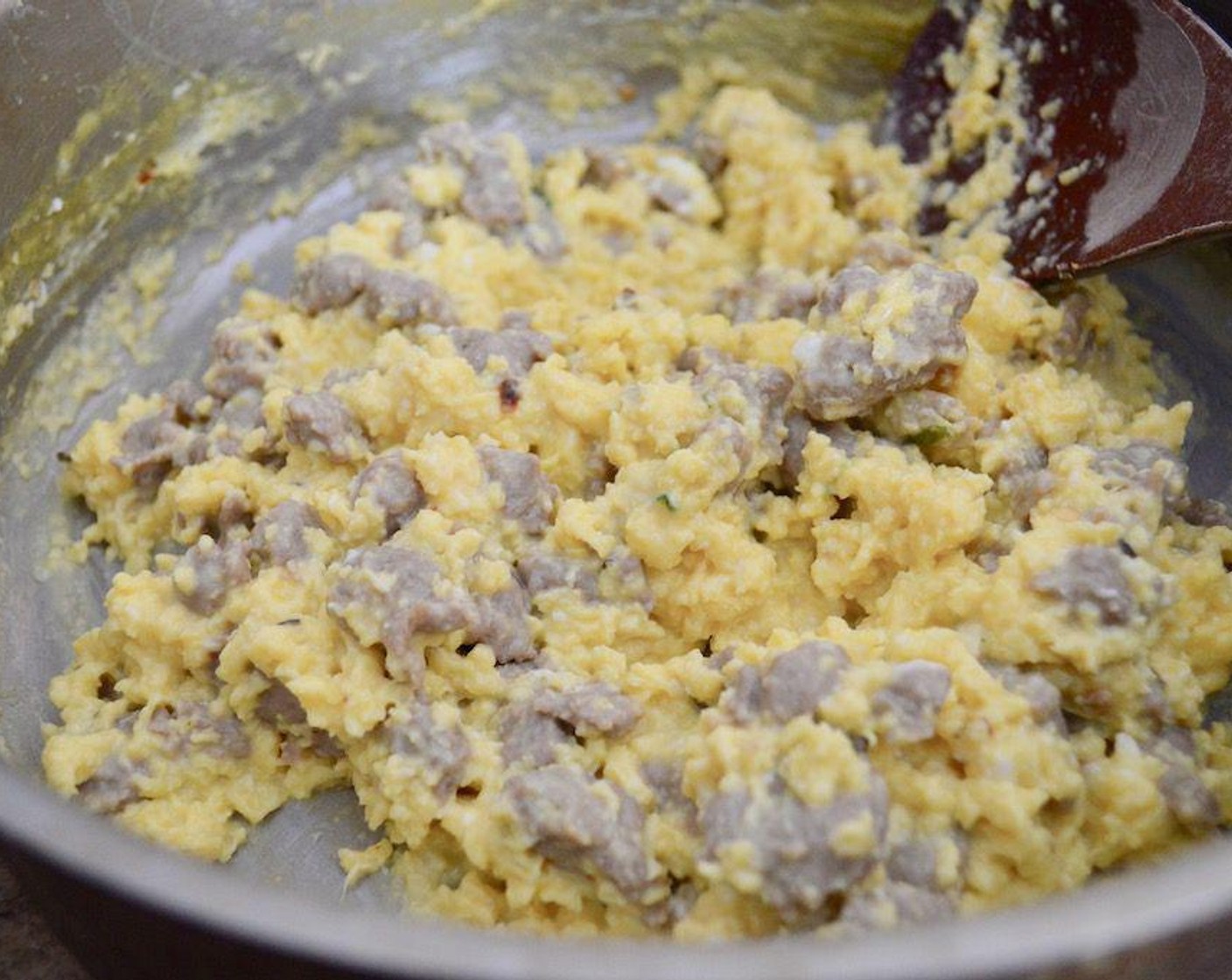 step 4 Meanwhile, whisk the Eggs (6), Milk (1 Tbsp), Fresh Chives (4 stalks), Salt (1 pinch), and Crushed Red Pepper Flakes (1 pinch) together thoroughly. Pour that into the pan of cooked sausage and scramble the eggs completely until they form soft curds. Turn off the heat and stir in the Whipped Chive Cream Cheese (2 Tbsp).