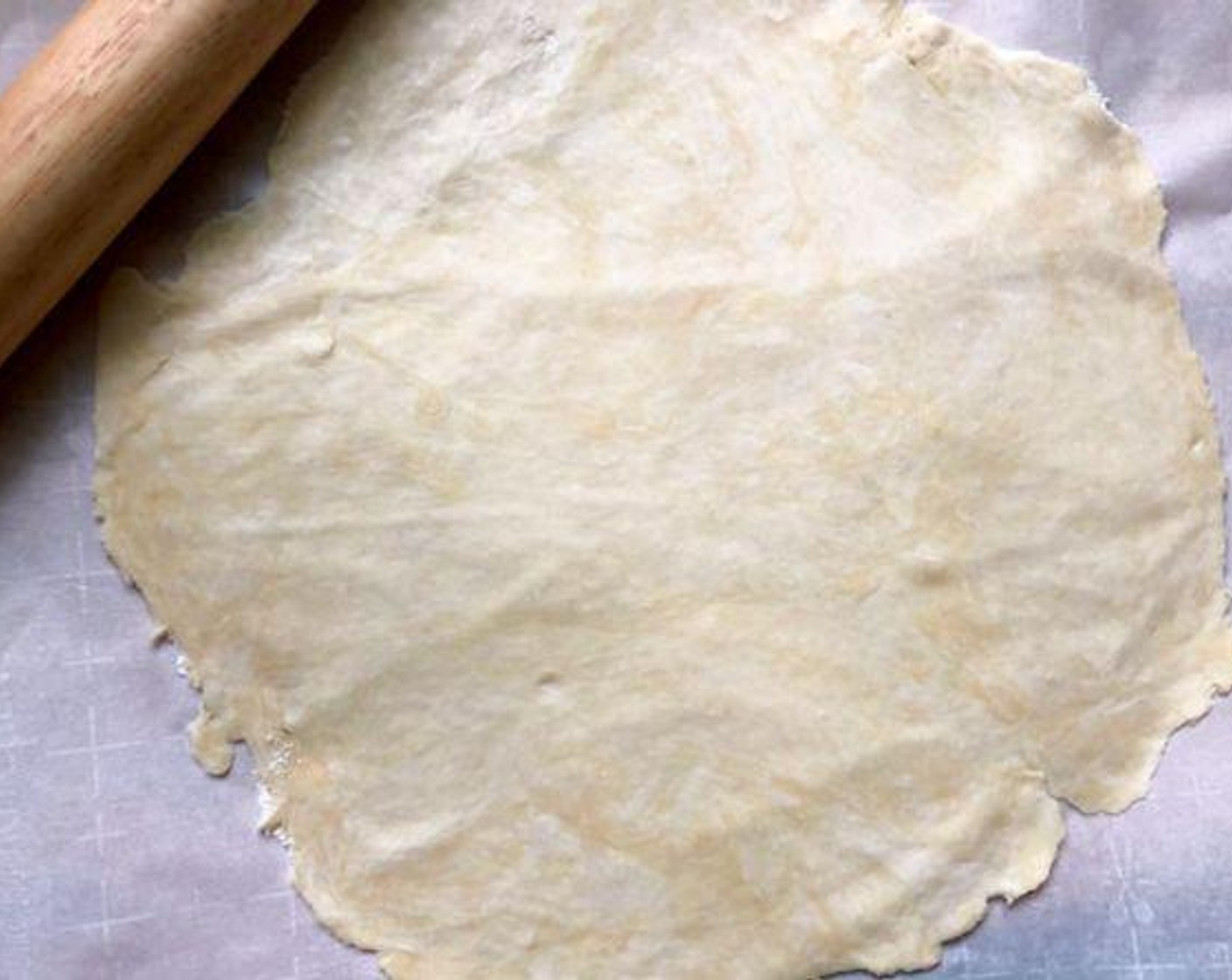 step 5 On a large piece of lightly floured parchment paper, roll pastry into a 13-inch circle. Slide the paper with the pastry onto a baking sheet. Set aside.