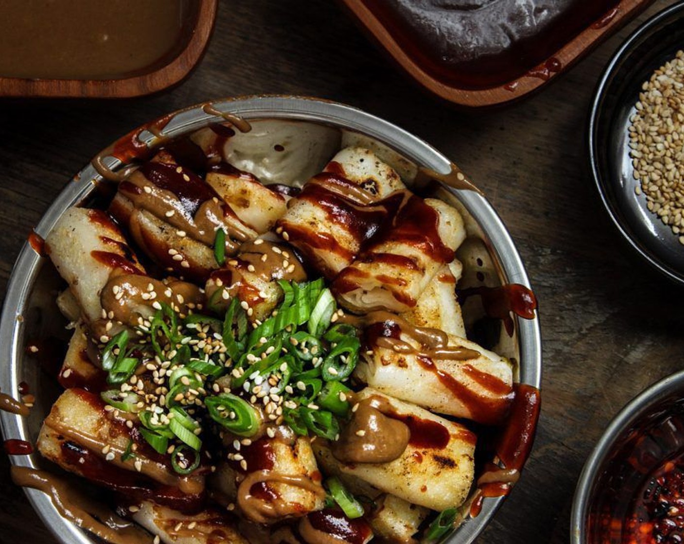 step 8 Drizzle (or drown) the rolls with sauce, garnish with Toasted White Sesame Seeds (1 Tbsp), Scallion (1 stalk), and Lao Gan Ma® Spicy Chili Crisp (to taste).