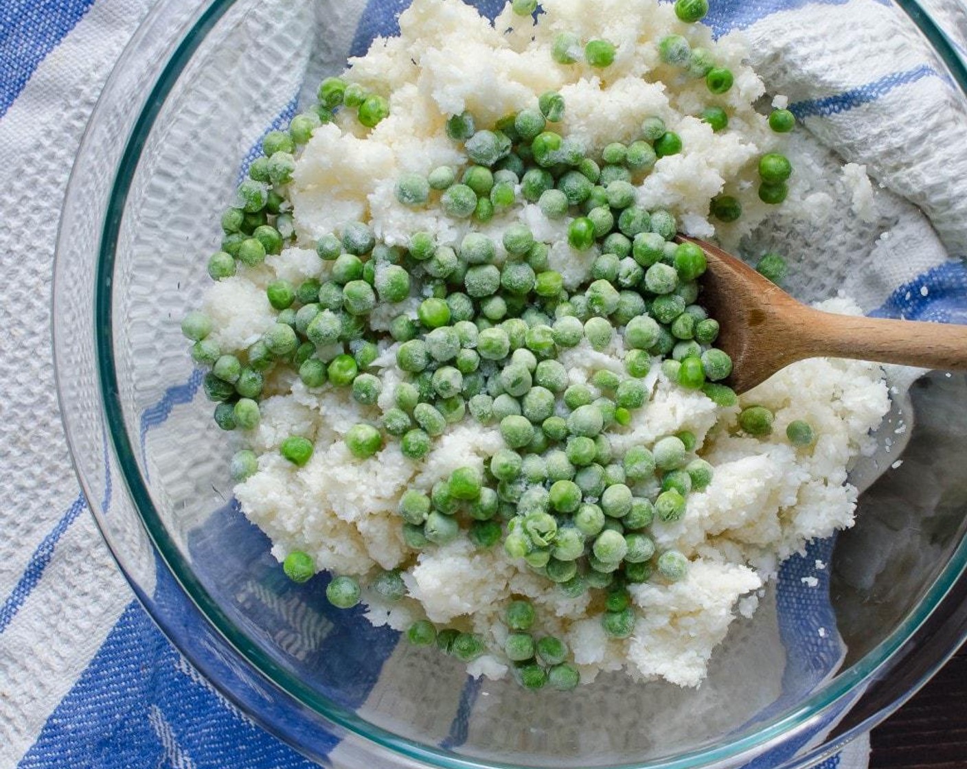 step 2 Transfer the cauliflower to a bowl. Add the Olive Oil (1 1/2 Tbsp), Garlic (1 clove) and Frozen Green Peas (1 cup). Toss to coat and cover tightly with plastic wrap. Microwave for 3 minutes on high power.