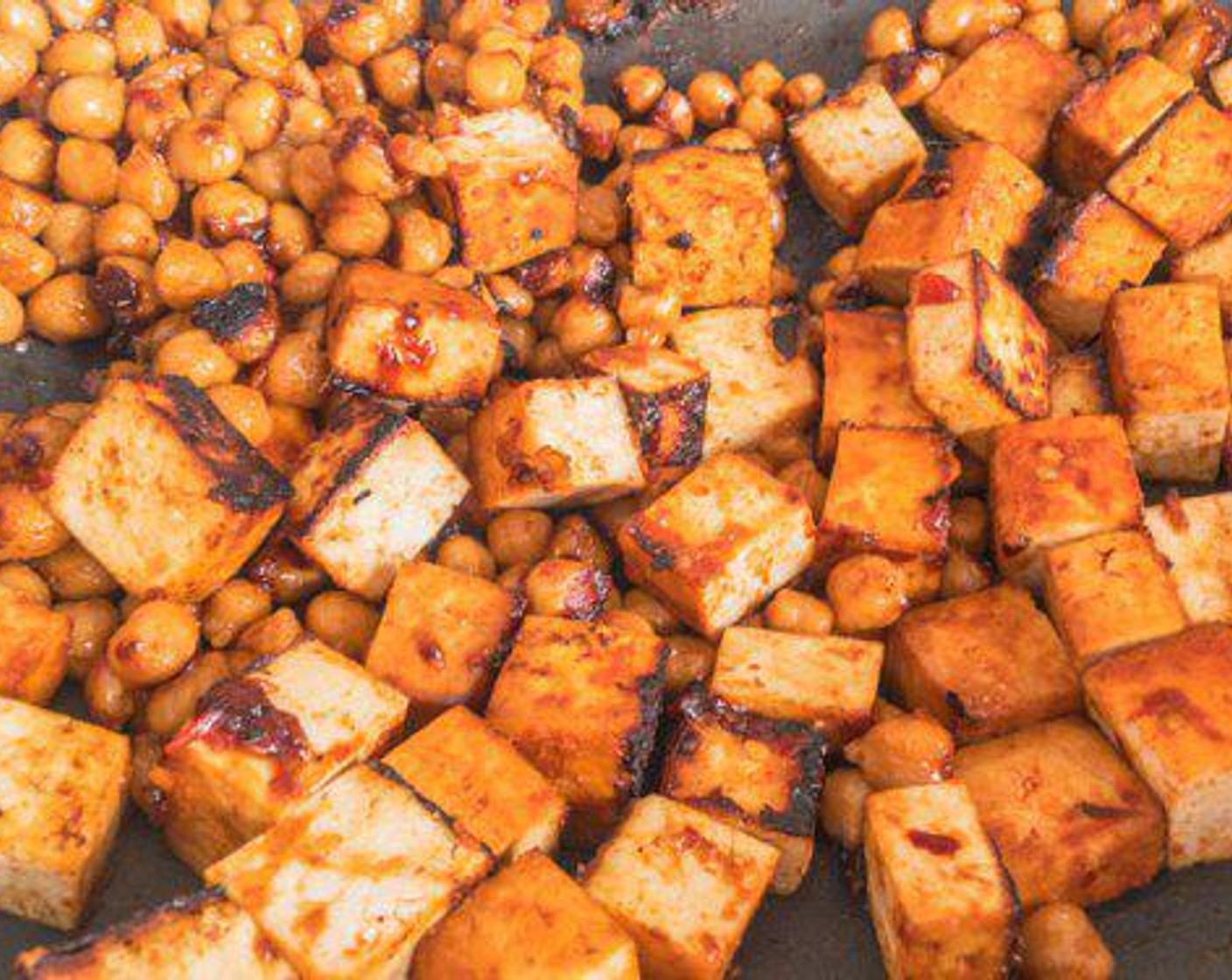 step 3 Add Grapeseed Oil (1 Tbsp) and Tofu (2 pckg) to the pan. Cook covered, mixing tofu every minute or so until most edges are brown.