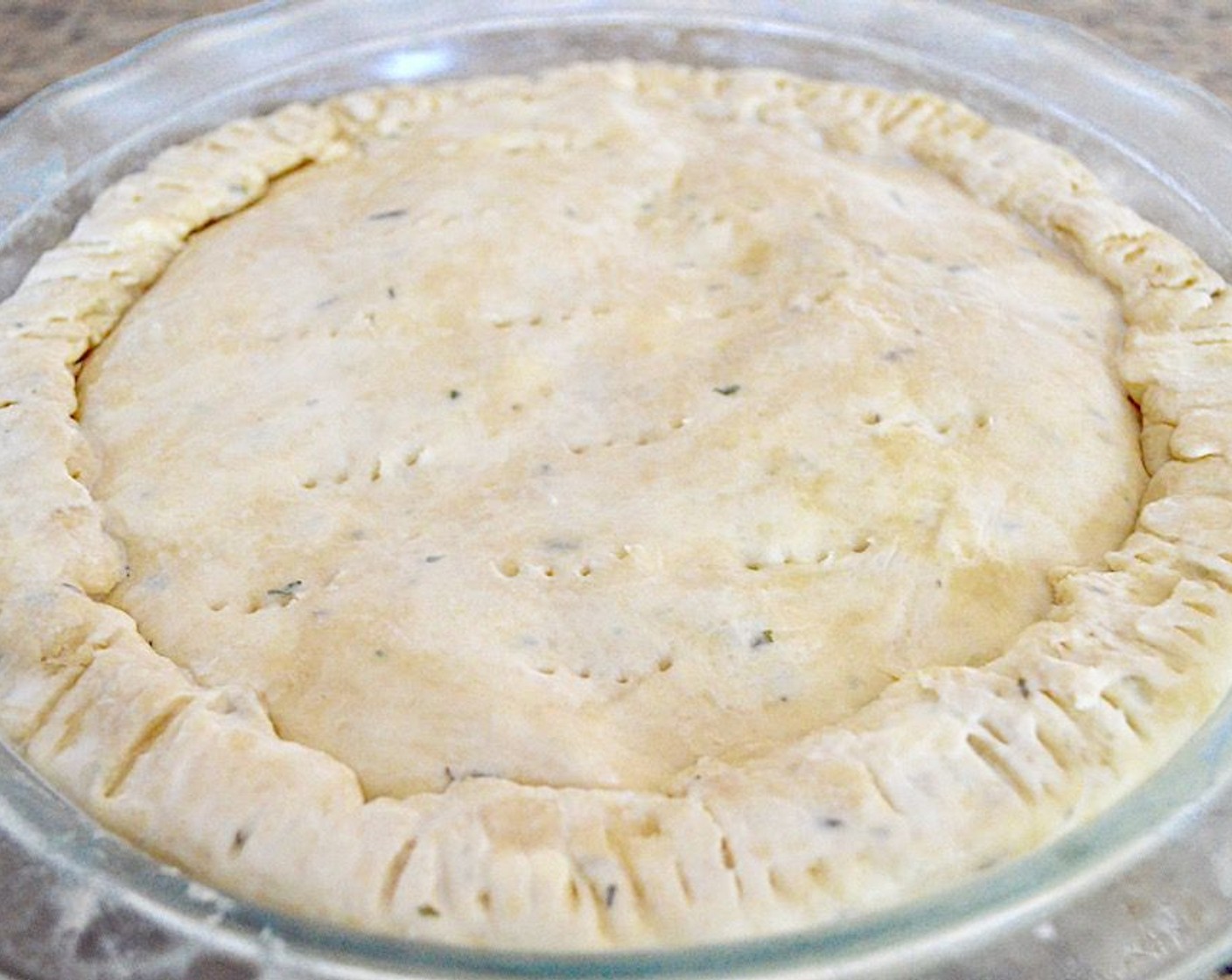 step 8 Spoon the filling into the crust and press it into a firm, even layer. Then take the second disc of dough out and roll it into another 10 inch disc. Place it on top of the filling and crimp the edges together firmly with the edges of the bottom disc.