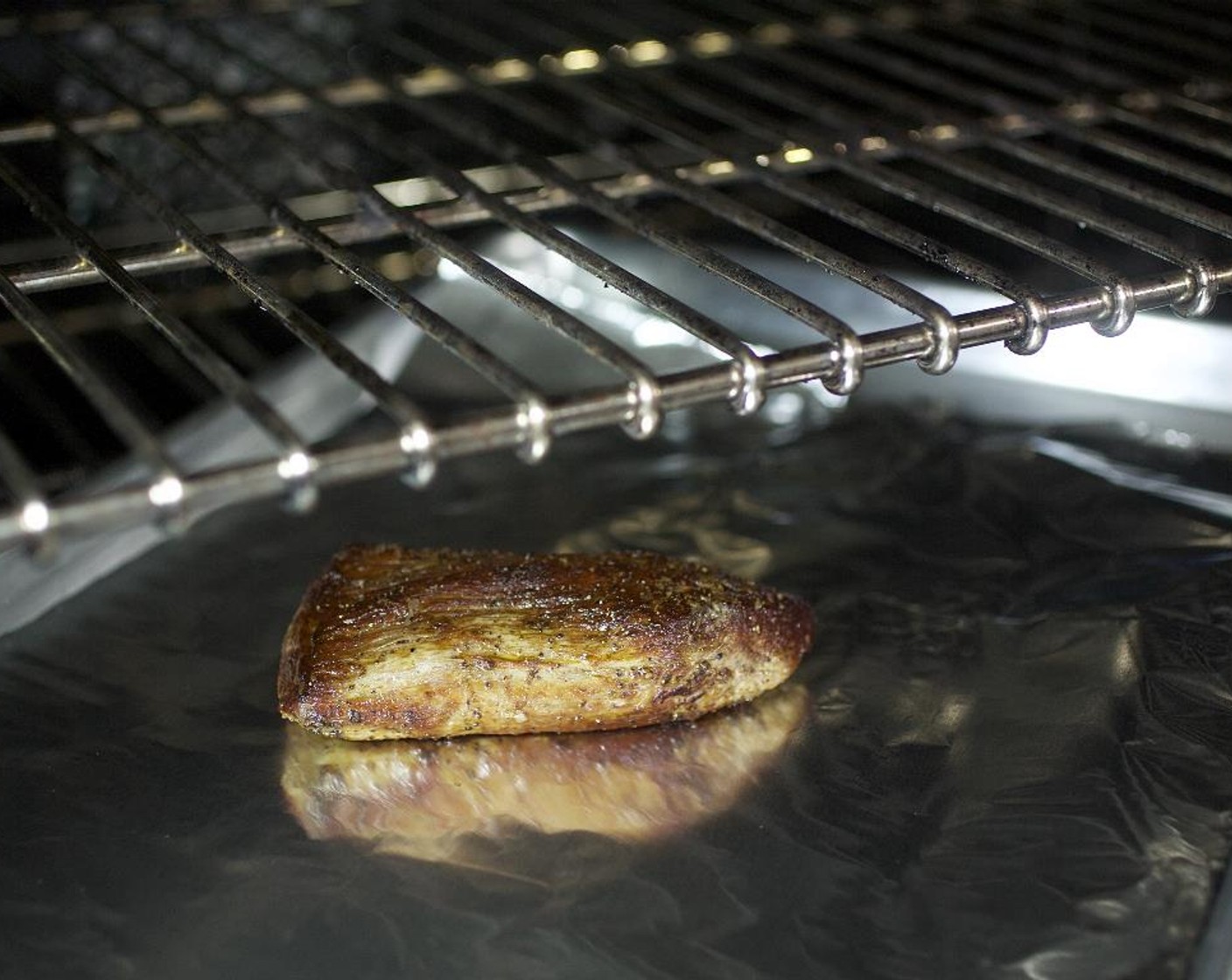 step 9 Place steaks on the foil-lined sheet pan and roast in the oven for 6 to 7 minutes.