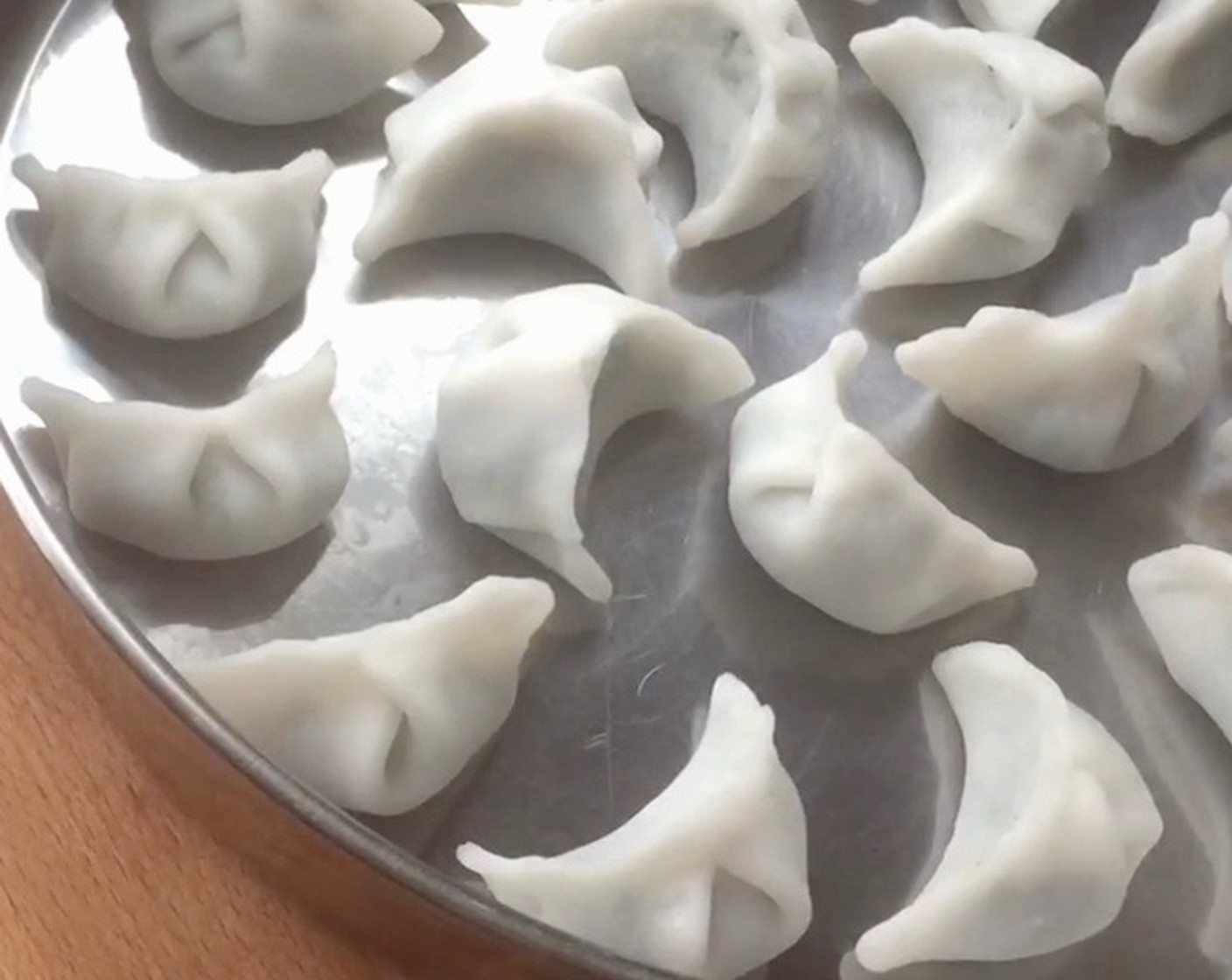 step 26 Arrange the pleated chive dumplings on the steaming tray.