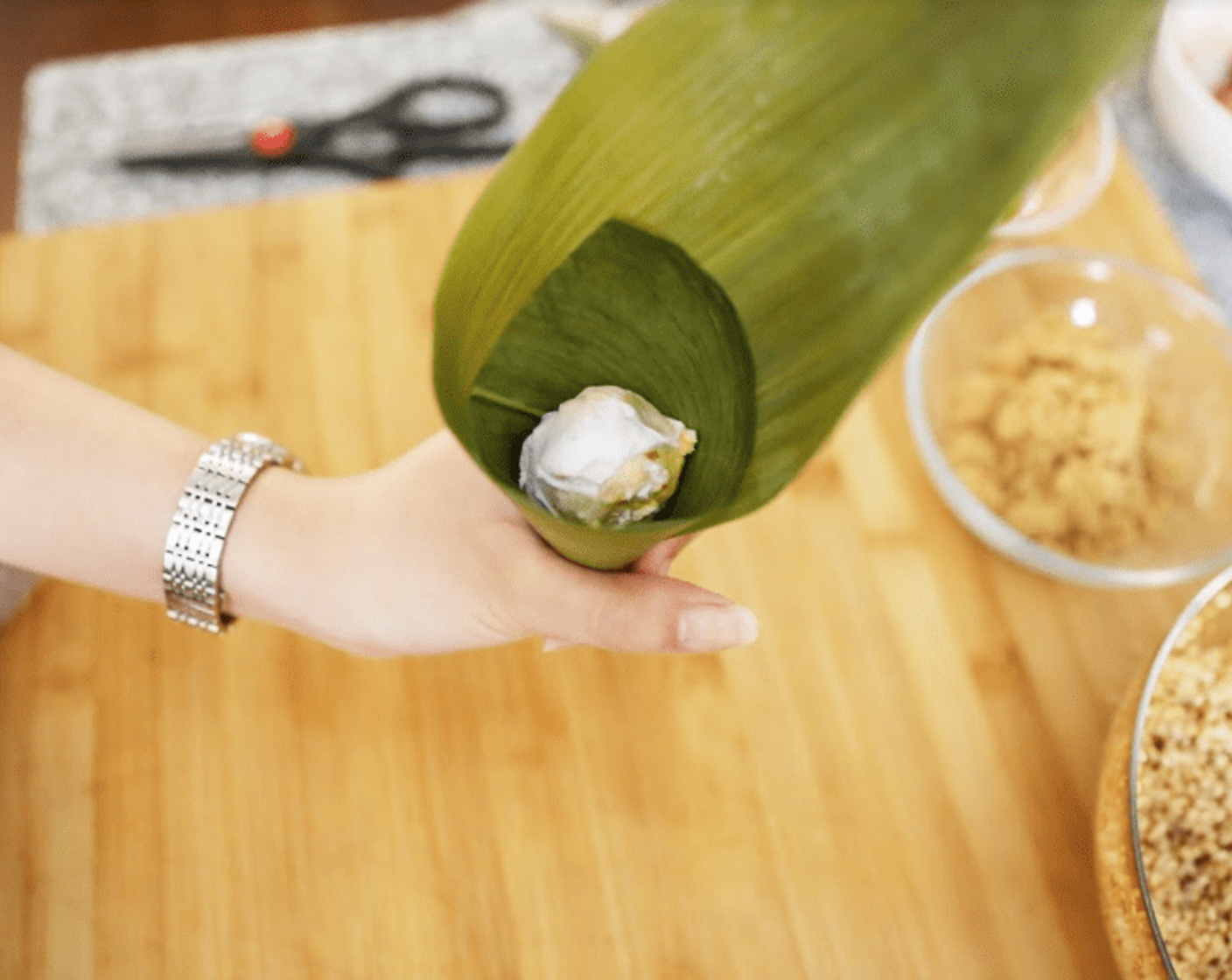 step 7 First, wrap each palm leaf into a cone safe and add in the rice.