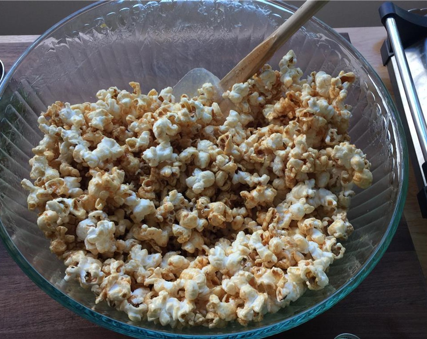 step 7 In a large mixing bowl, add the caramel and popcorn together in batches and fold together using a rubber spatula.