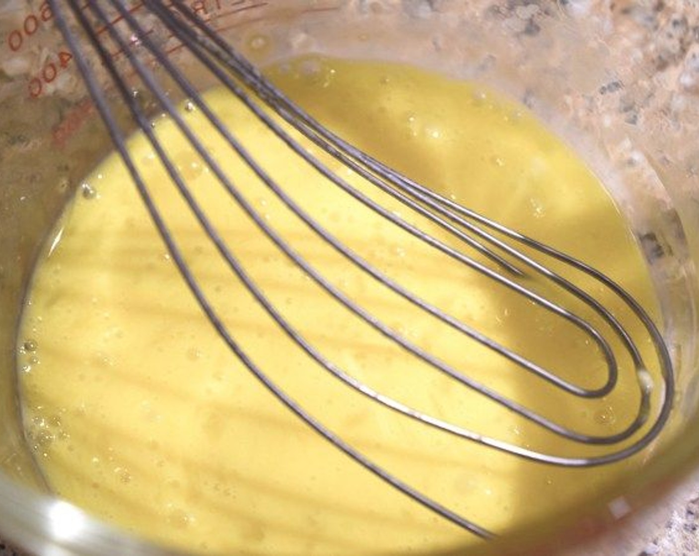 step 6 Next, whisk together one whole Eggs (2) and one egg yolk in a heat proof bowl. Then, slowly add one ladle full of the milk to the egg, stirring constantly to temper the eggs.