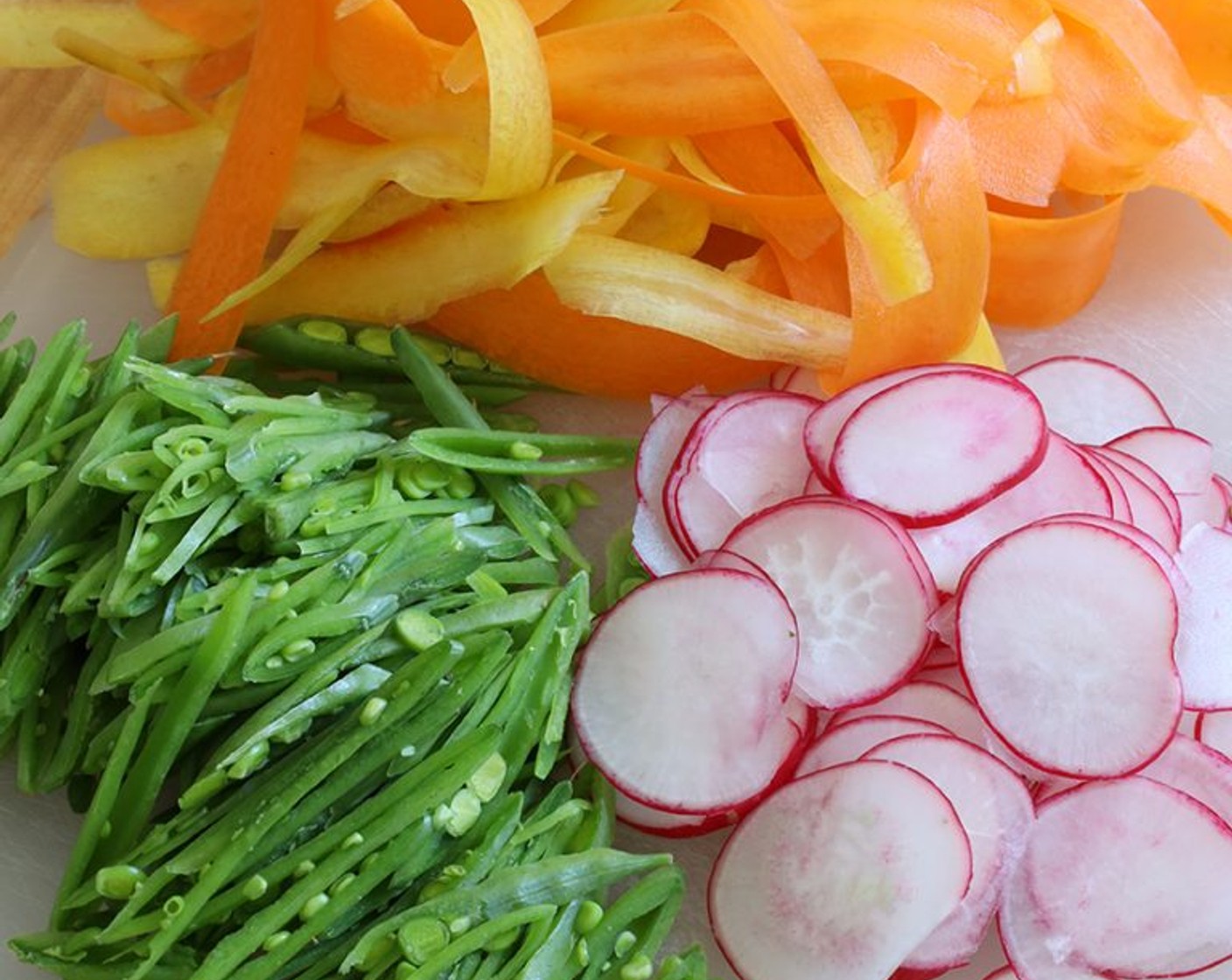 step 2 Place them in a large bowl, along with the Radish (1 bunch). Thinly slice the Sugar Snap Peas (1 cup) lengthwise and add them to the bowl.