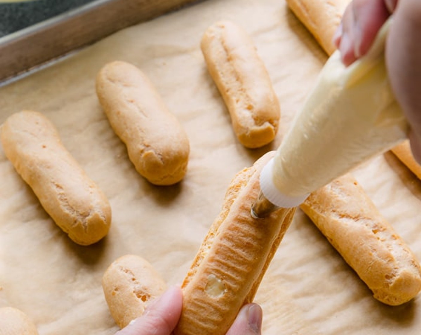 step 21 To assemble eclairs, using a sharp pairing knife, make two holes on the bottom of each eclair shell and fill the pastry shells through the holes until the eclairs are filled.