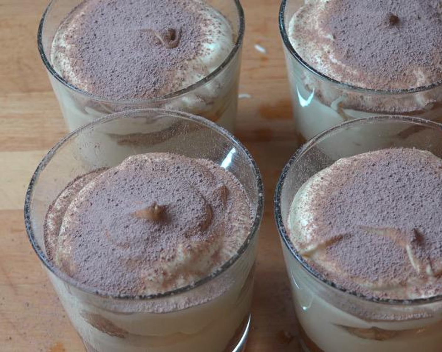step 5 To assemble the tiramisu cups, break biscuits in half and press two halves into the bottom of each serving glass. Spoon over the cream mixture. Repeat the layers once more in each glass. Dust Unsweetened Cocoa Powder (to taste) on top.