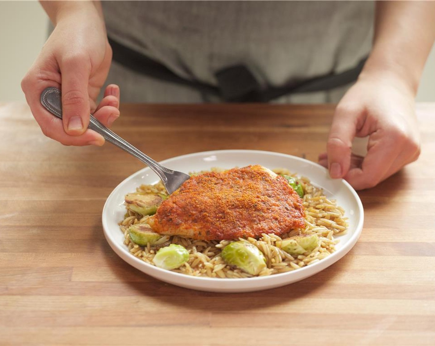 step 12 Divide the orzo between two plates. Lay a piece of tilapia over the pasta.