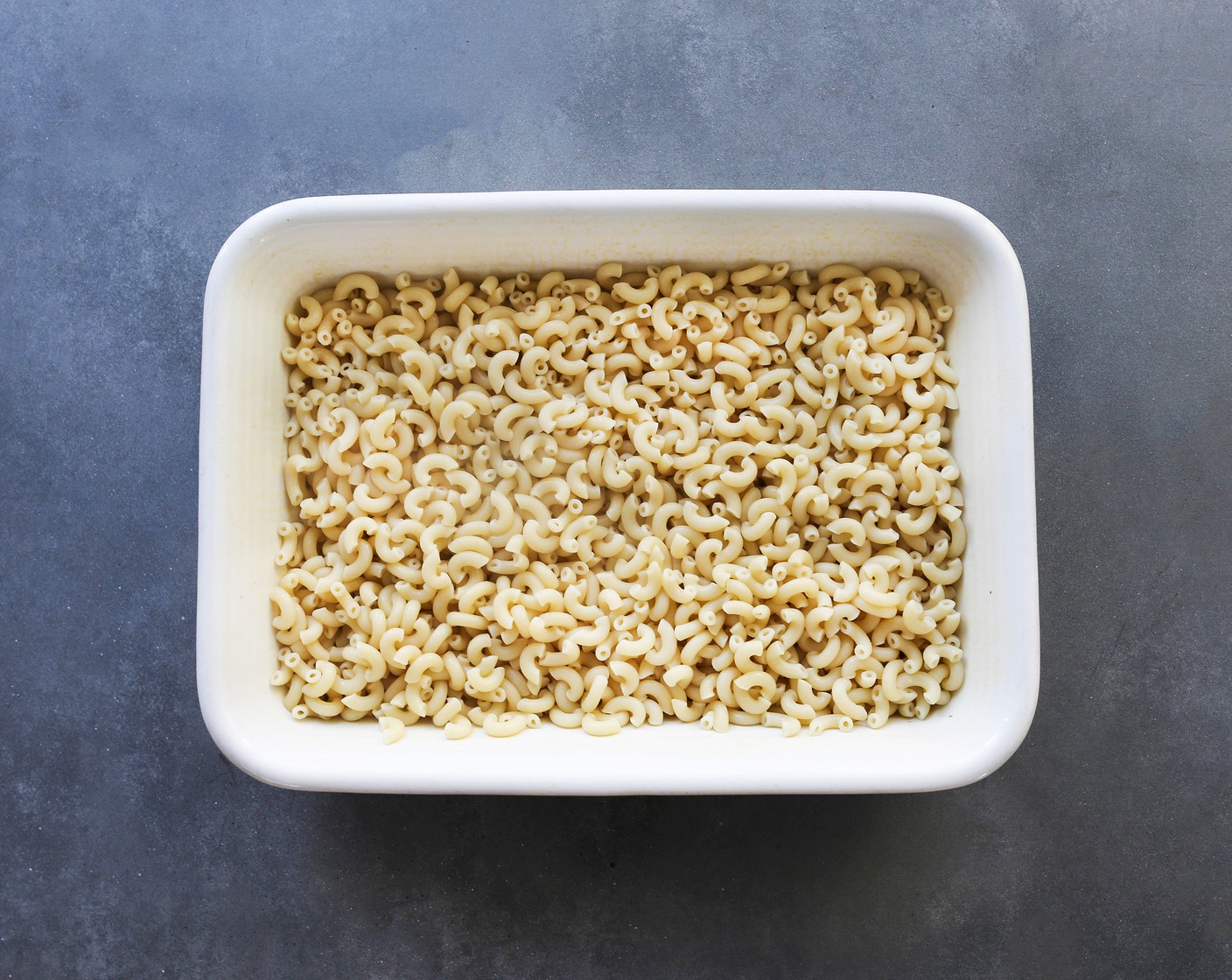 step 3 Drain, rinse, and add the cooked pasta to the prepared pan in a single layer.