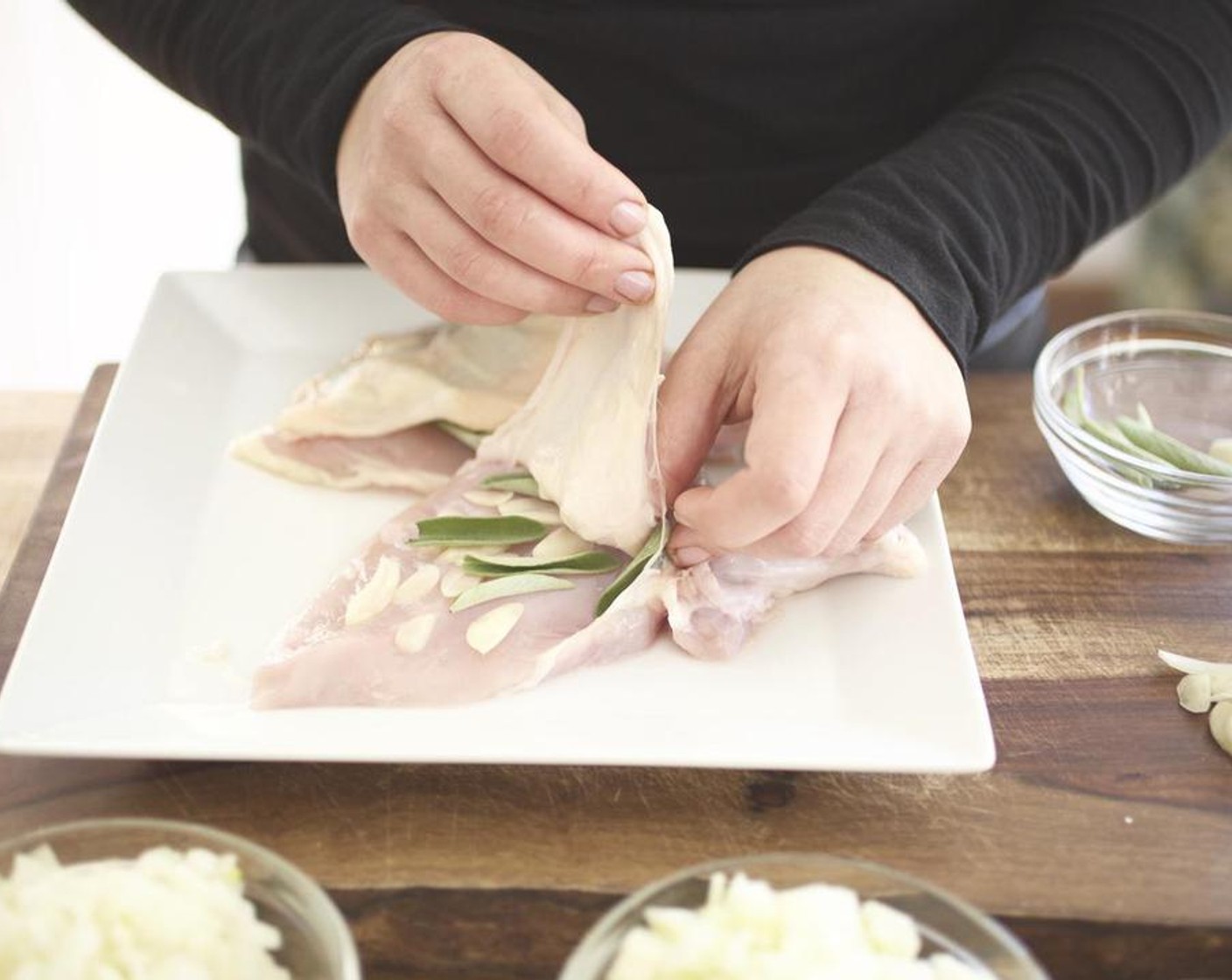 step 6 Place the leaves under the skin with the garlic, keeping the leaves flat. Pull the skin back over the breast. Season each skin side with Salt (1/4 tsp) and Ground Black Pepper (1/4 tsp).