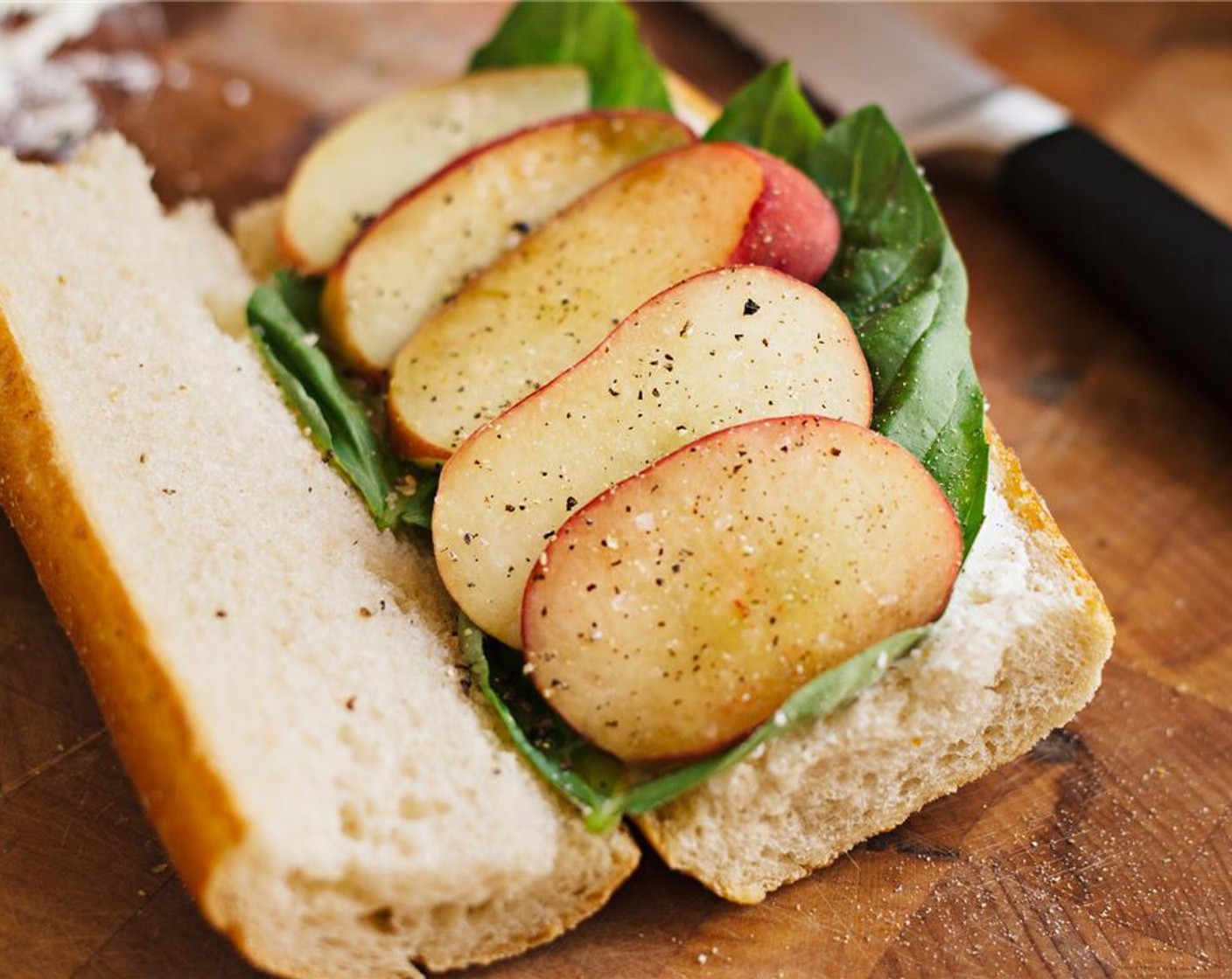 step 3 Assemble the sandwiches. Spread half the Goat Cheese (1/3 cup) on the bottom halves, follow with the Fresh Basil Leaves (8) and then the peaches. Sprinkle with Salt (to taste) and Ground Black Pepper (to taste).