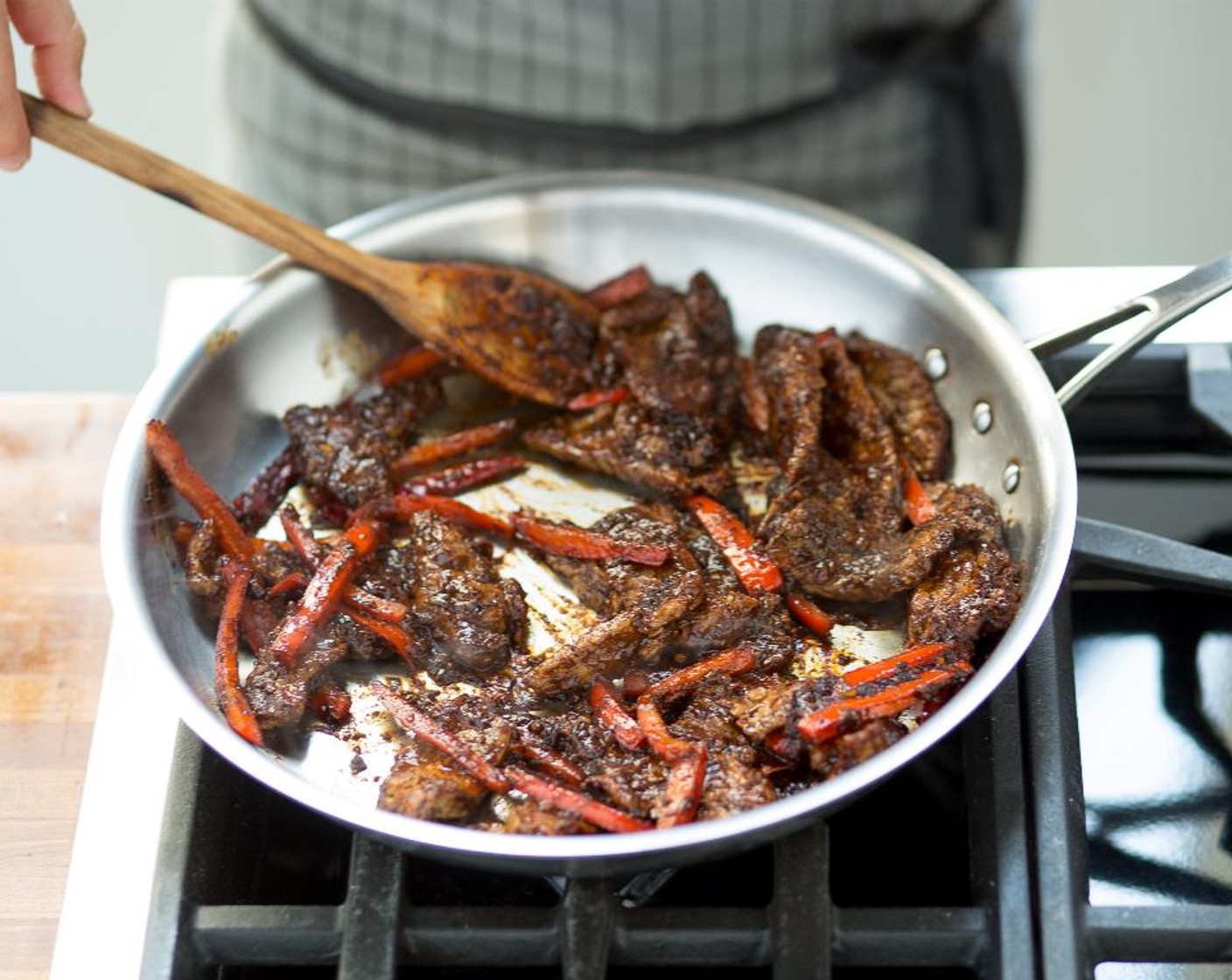 step 7 Add more Canola Oil (1 Tbsp) to the hot pan and add the Dried Chili Peppers (5), Fresh Ginger (1 1/3 Tbsp), Garlic (3 cloves) and Red Bell Pepper (1) and stir-fry for 5 minutes or until slightly browned.