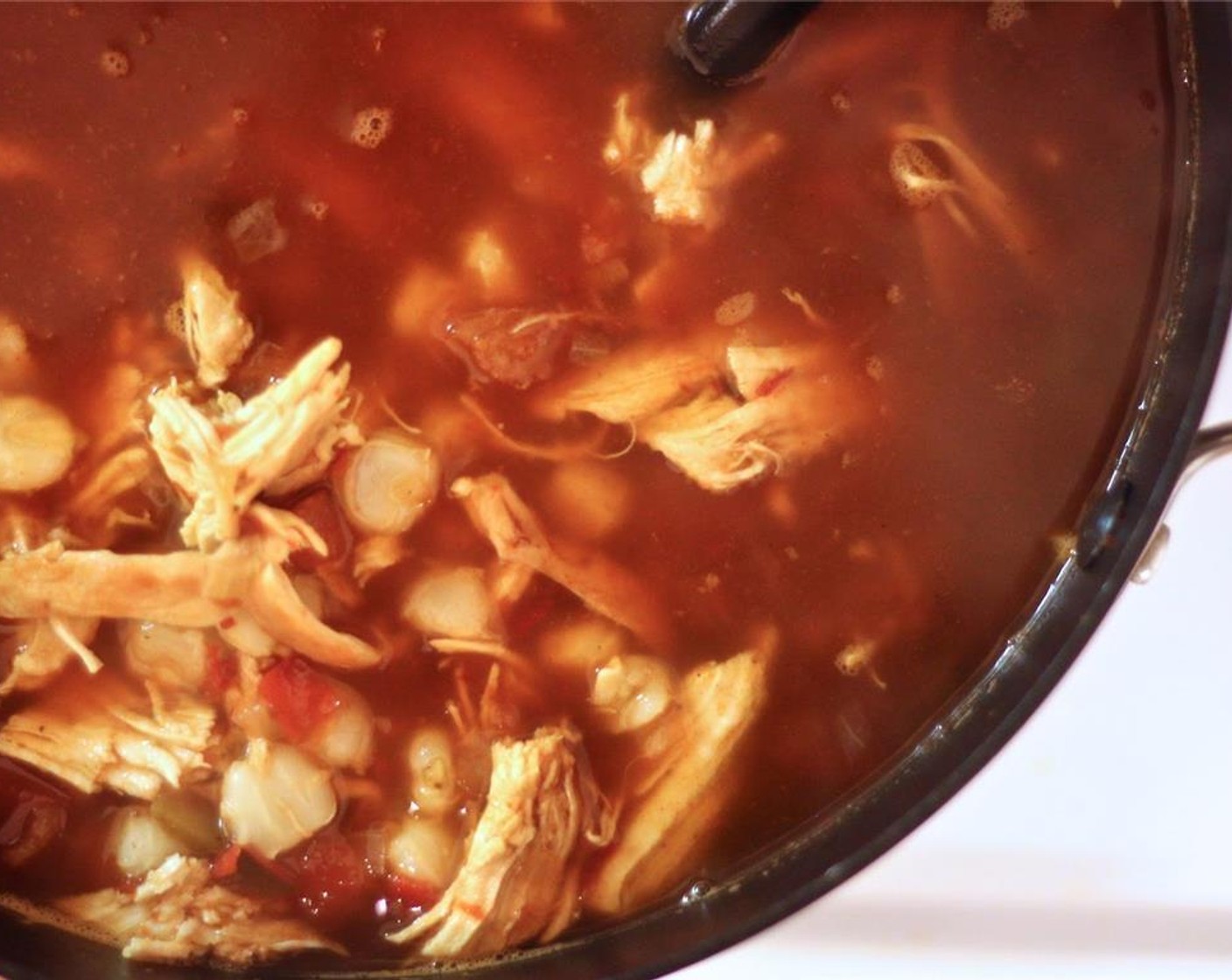 step 10 When the chicken is done, remove each breast and shred the meat with two forks. Add it back to the pot along with the White Hominy (2 cups) and return to high heat.