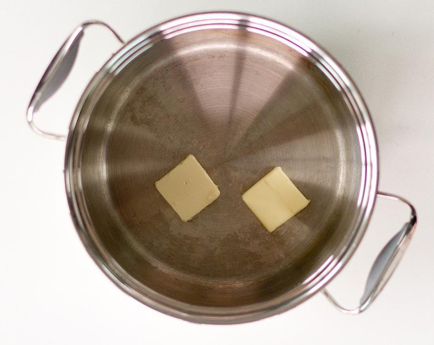 step 8 Using a medium sized pot, heat the remaining Unsalted Butter (2 Tbsp). Add Garlic and Yellow Onion and cook until the onions begin to soften.