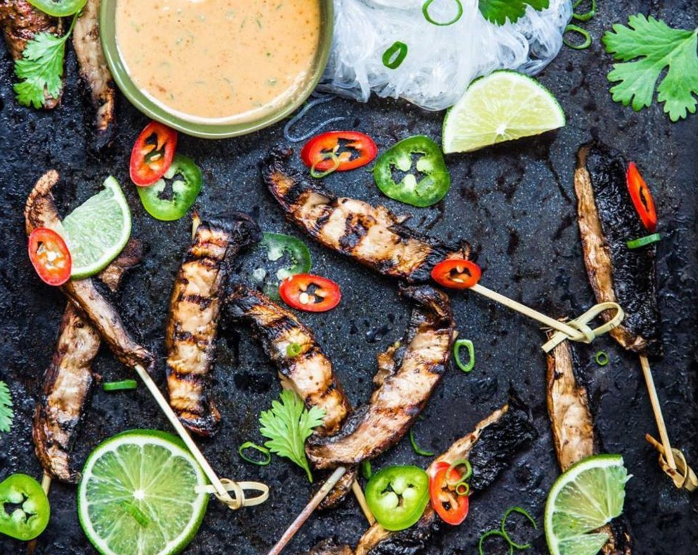 step 8 Remove mushrooms from grill and garnish with slices of remaining Lime (1), Jalapeño Peppers (to taste), Anaheim Chili Peppers (to taste), remaining Scallion (1), and Fresh Cilantro (to taste).