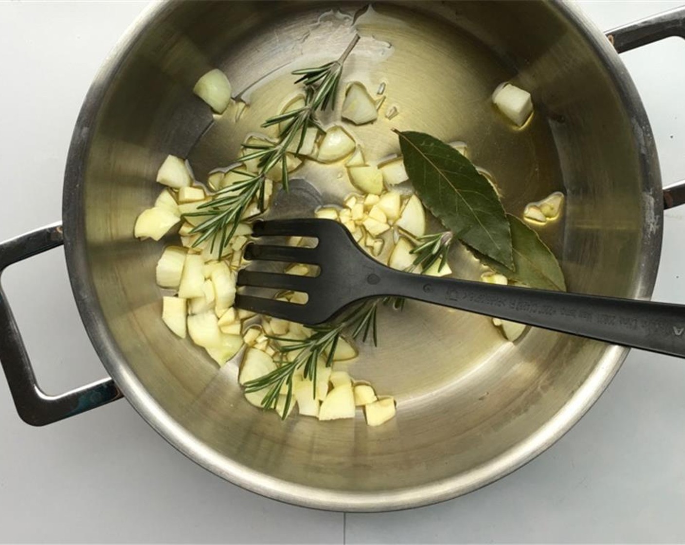 step 1 Peel and chop the Yellow Onion (1) and Garlic (4 cloves). Add this together with the Bay Leaves (2) and the fresh Fresh Rosemary (2 sprigs) to a large casserole. Sprinkle with the Olive Oil (3 Tbsp).