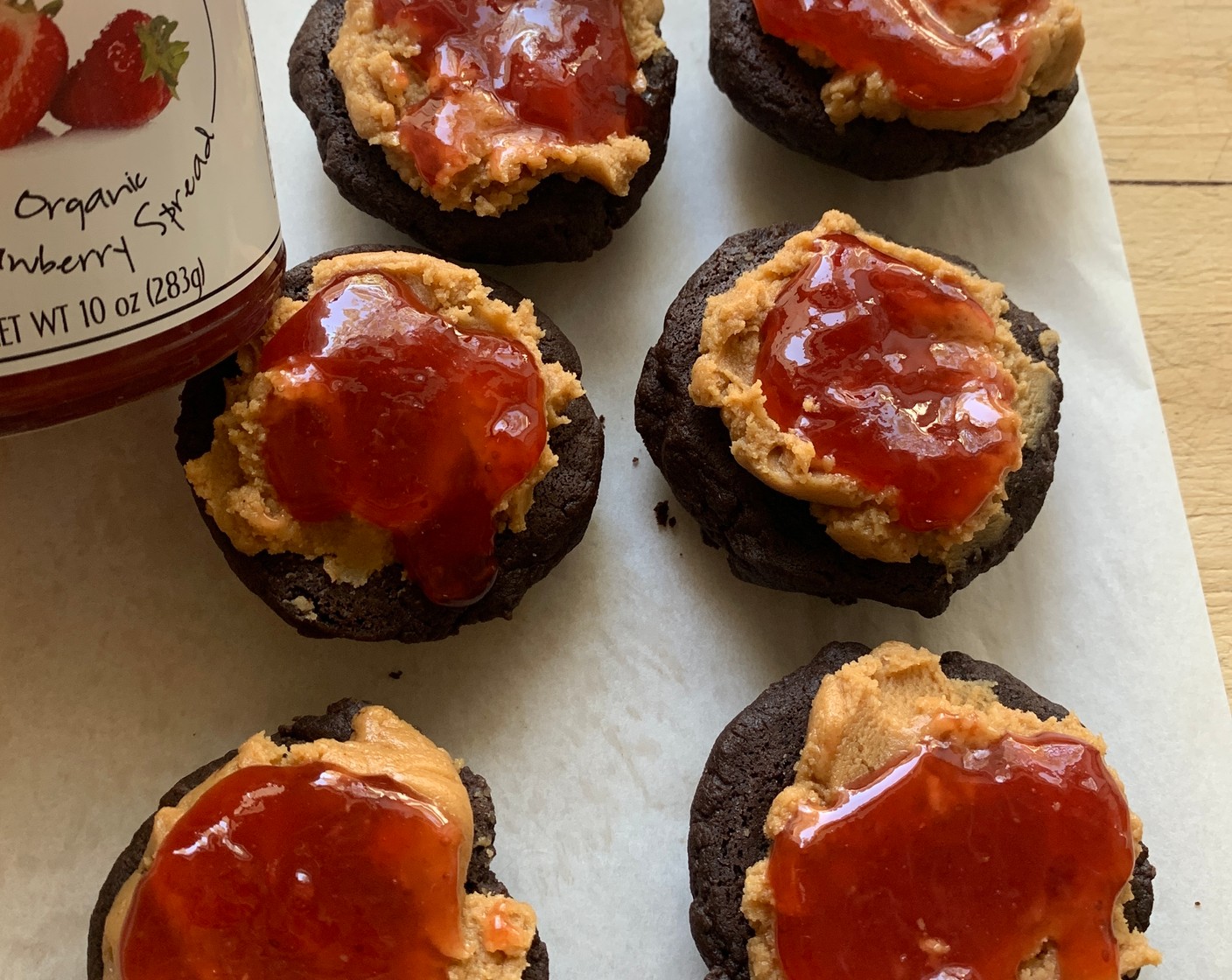 step 8 Once cooled, gently lift the cakes off the parchment paper and spread about 2 tablespoons of buttercream onto the flat side. Spread a generous teaspoon of Just Jan’s® Organic Strawberry Spread (3 Tbsp) on top of the peanut butter and top with another cake.