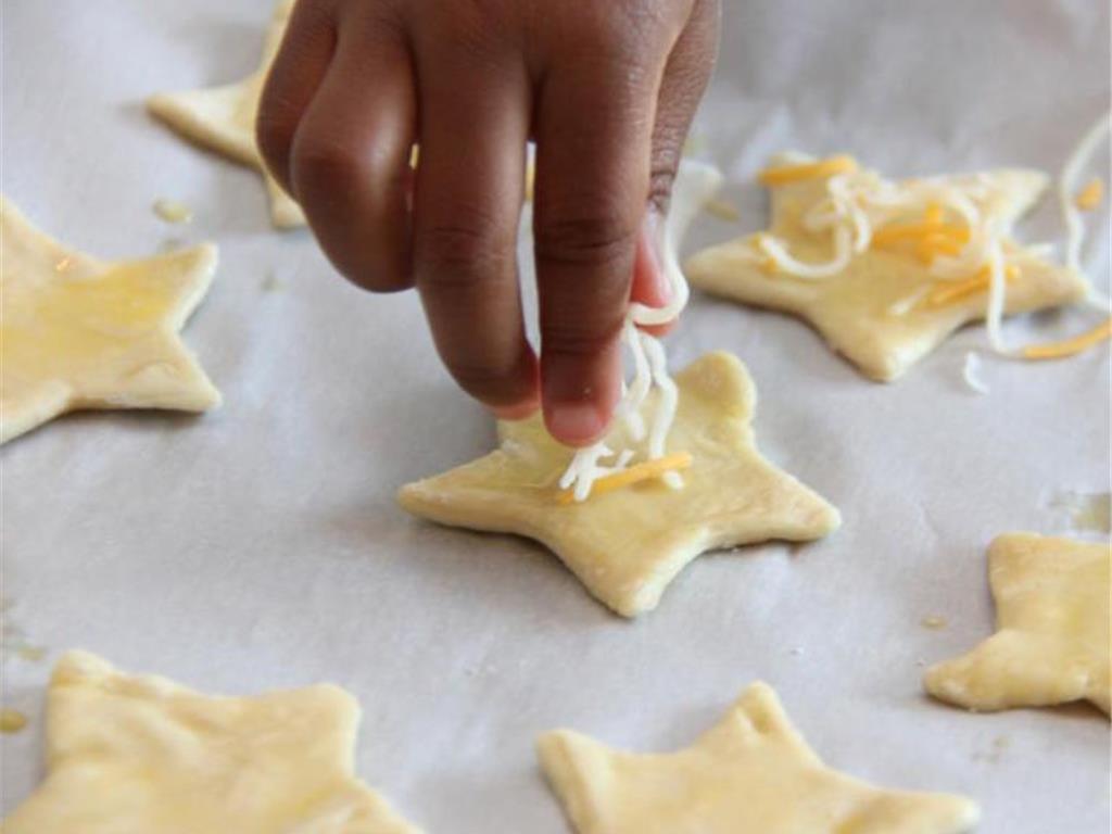 Step 5 of Easy Peasy Cheesy Puffs Recipe: Sprinkle a little Shredded Mexican Cheese Blend (1/4 cup) onto each shape.