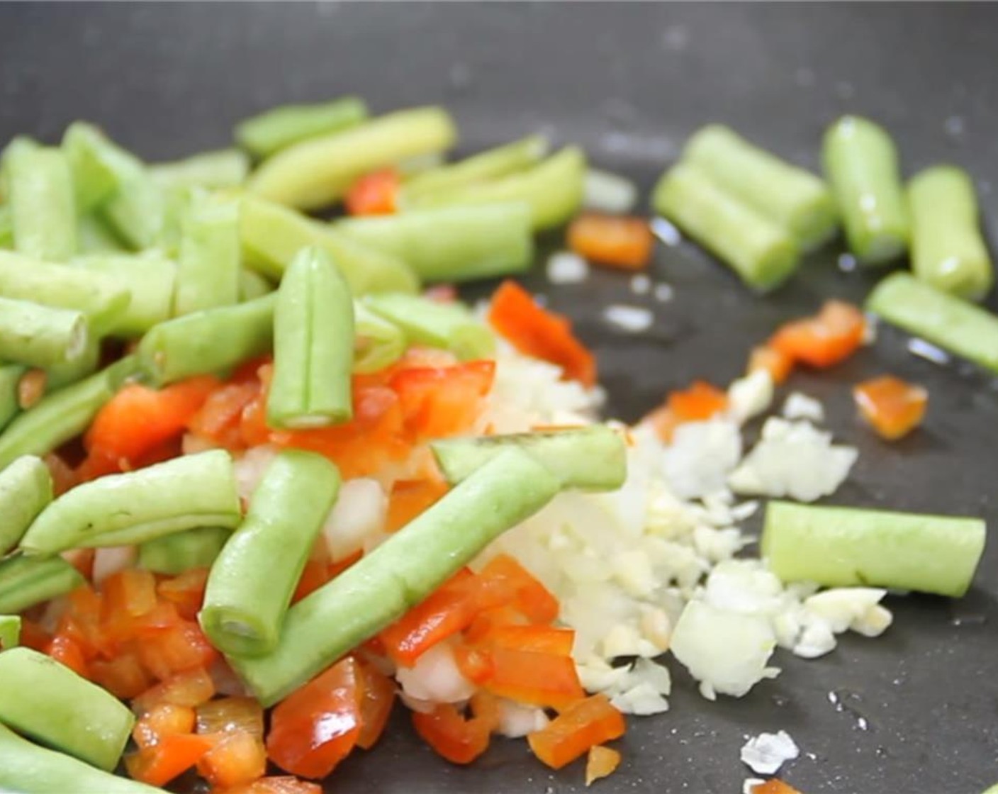 step 3 Add a bit more oil to the same pan. Add the chopped Onion (1/2), chopped Garlic (2 cloves), chopped Green Beans (1 bunch), and chopped Red Bell Pepper (1). Saute them for a minute of two. Season with Salt (to taste) and Ground Black Pepper (to taste).