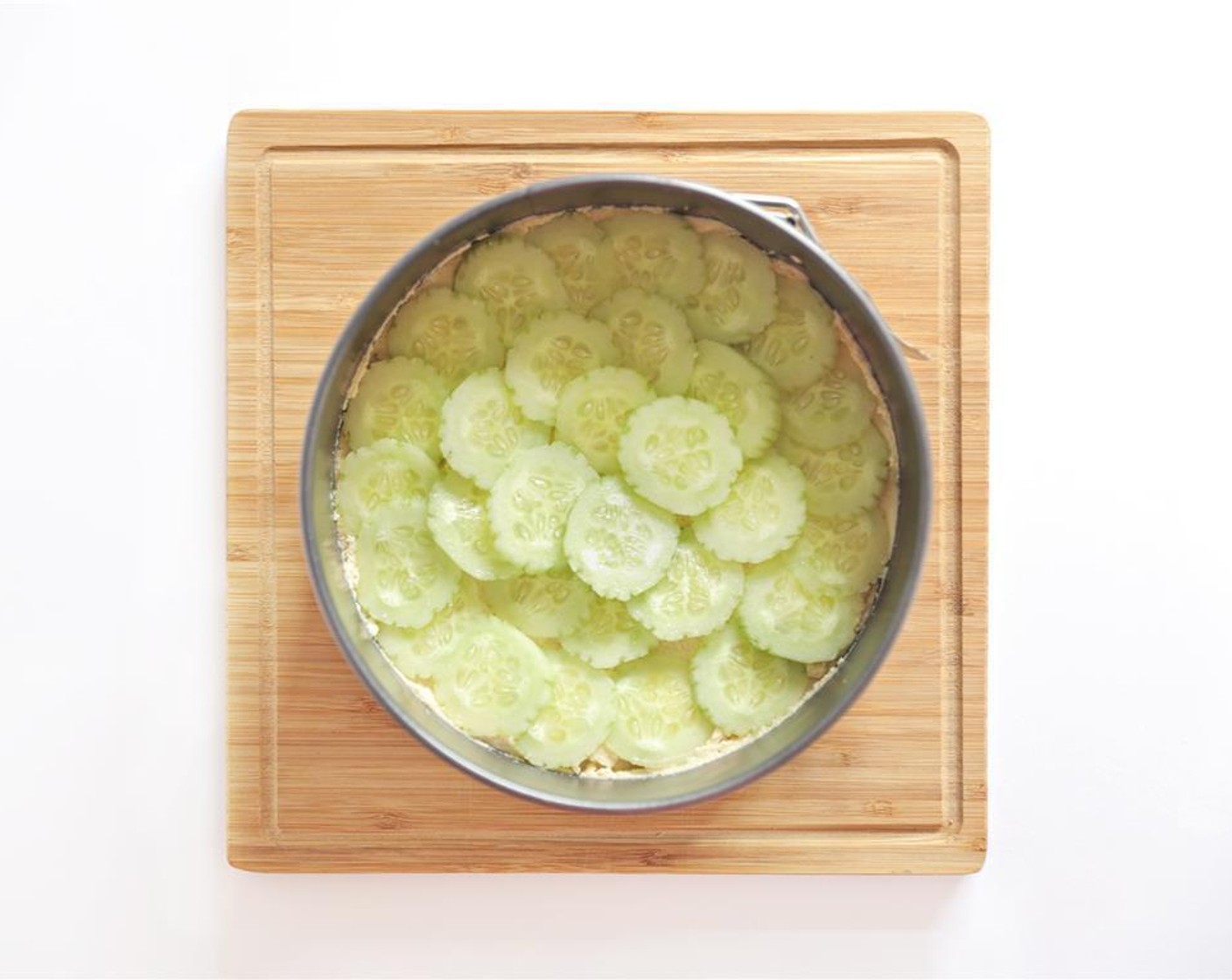 step 2 Using the back of the spoon, spread Hummus (1/2 cup) over the bread. Peel and thinly slice the English Cucumbers (2) and arrange over the hummus.