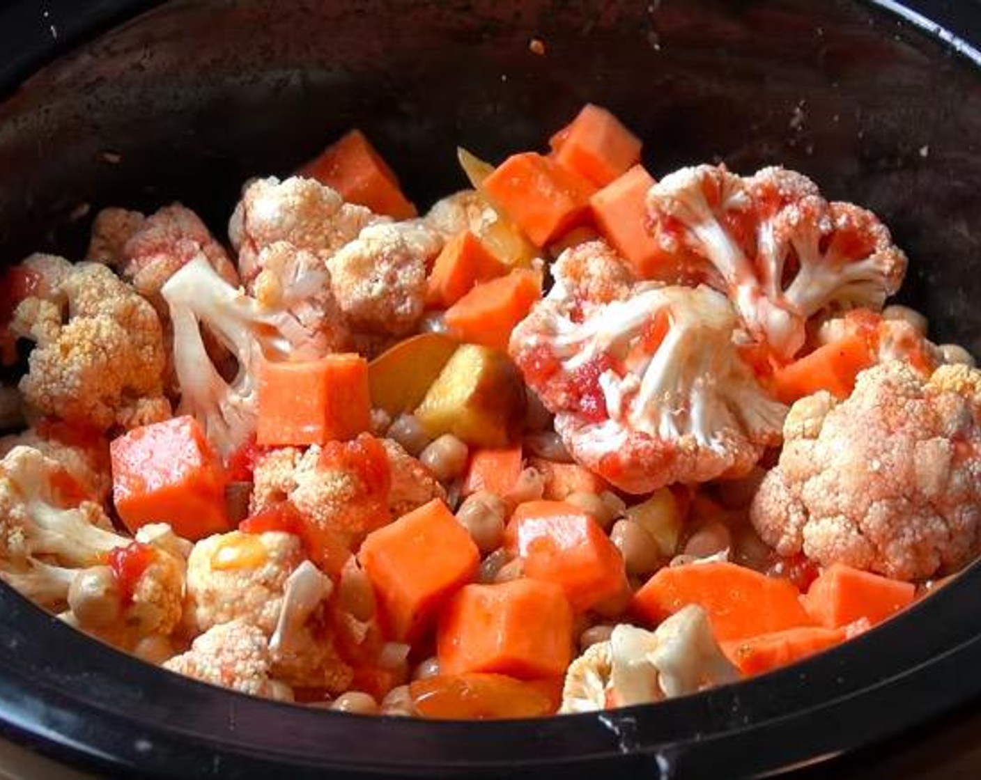 step 3 Transfer onion and apple mixture to slow cooker. Add Sweet Potatoes (1.3 lb), Cauliflower (3 3/4 cups) broken up into florets, Canned Chickpeas (4 1/4 cups), Canned Diced Tomatoes (1 3/4 cups) and Vegetable Stock (1 3/4 cups). Stir together.