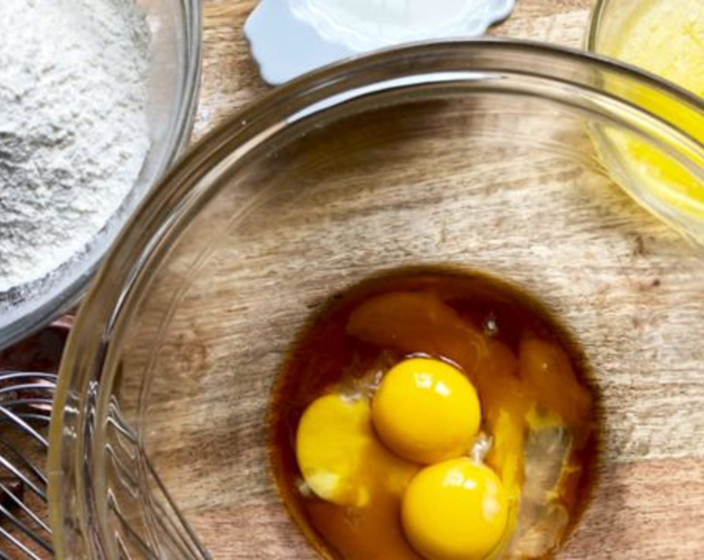 step 2 Put the yolks of the Eggs (3), Milk (1 cup), Unsalted Butter (1/4 cup), and Pure Vanilla Extract (1/2 Tbsp) into another bowl and beat well.