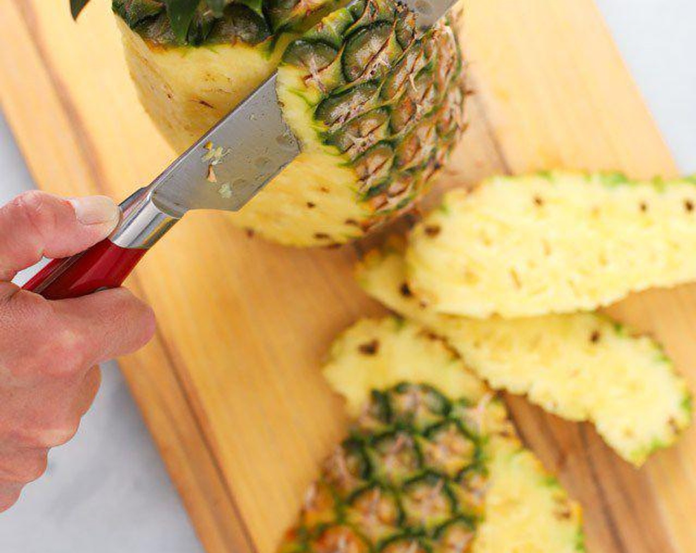 step 4 Cut off the sides of the Pineapple (1) with a large knife.