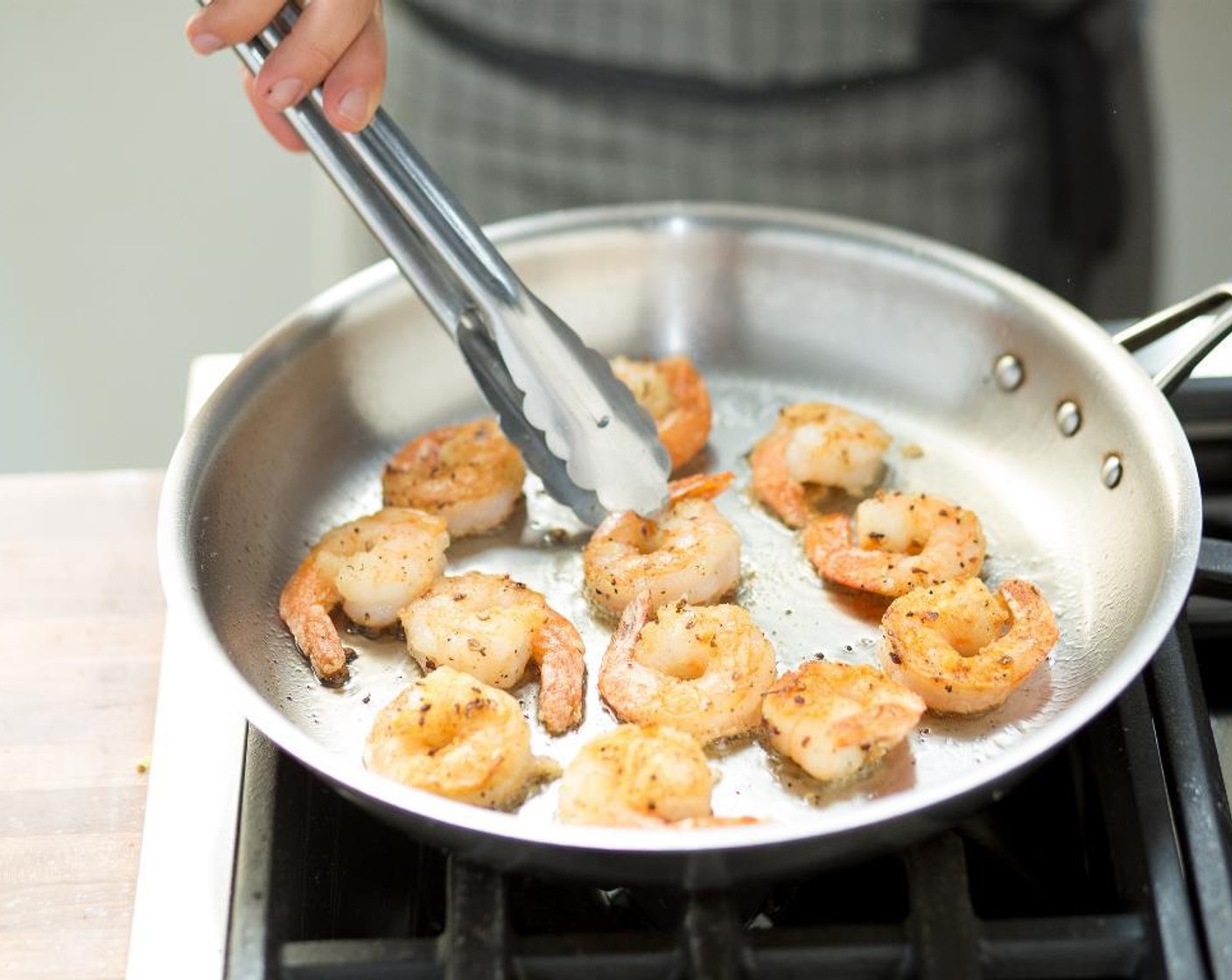 step 6 Heat Canola Oil (1/2 cup) l in a large sauté pan over medium-high heat. When hot, add the shrimp and fry for about 45 seconds on each side, or until they just curl. Drain the shrimp on paper towels, then toss in the medium bowl with the seasoning mix and coat each shrimp well.