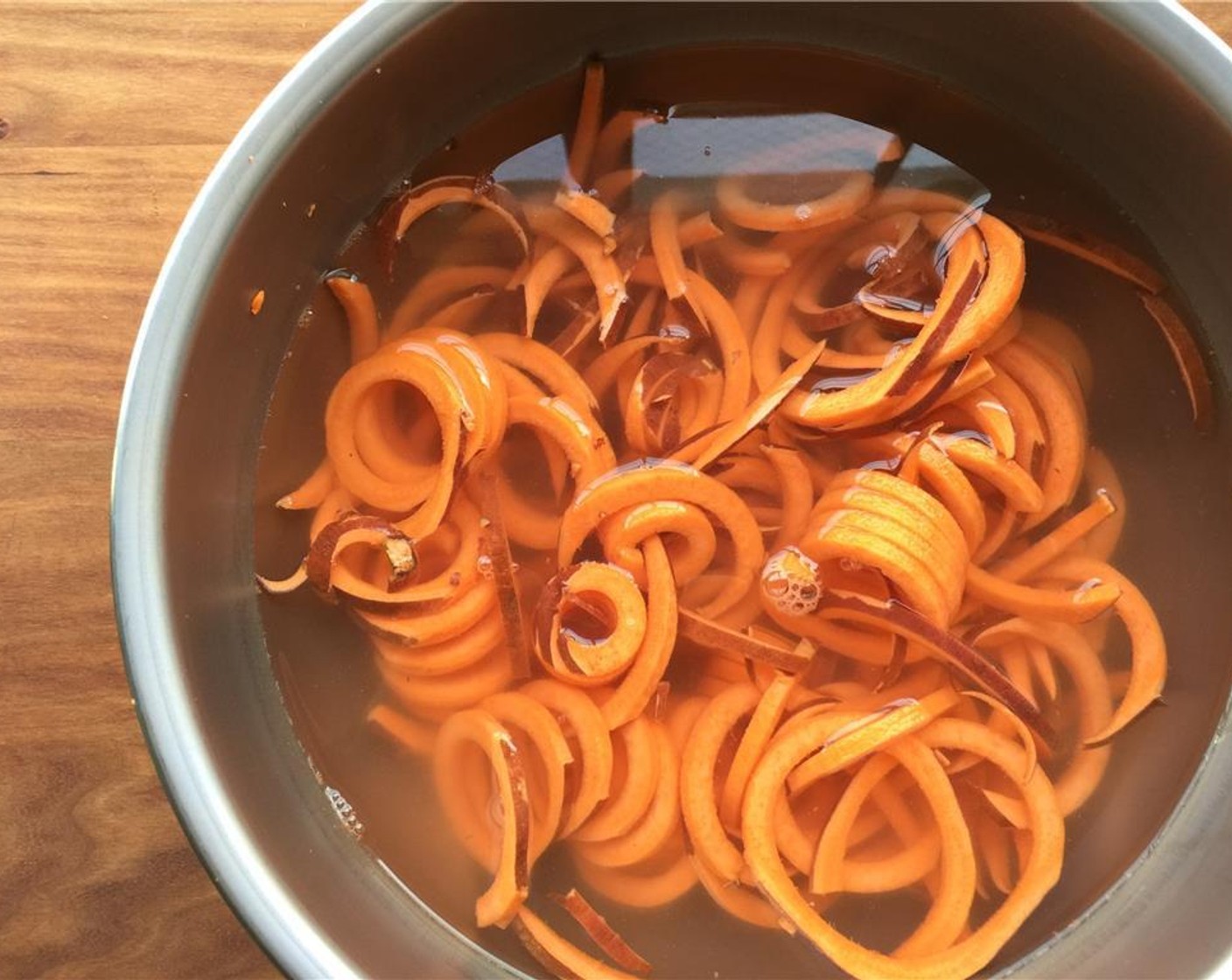 step 11 Spiralize the sweet potatoes or use a julienne peeler. Leave the skin on. Place in a bowl of cold water and set aside.
