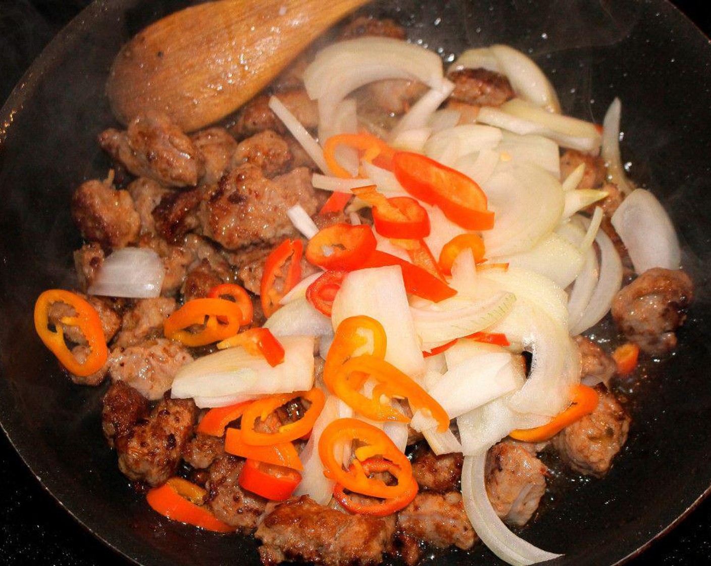 step 4 Sauté chorizo in Peanut Oil (as needed) until cooked through, then add julienned onion, freshly sliced chilies, and Chipotle Chili Powder (to taste). Sauté another 30 seconds, then remove to a serving bowl. Keep warm.