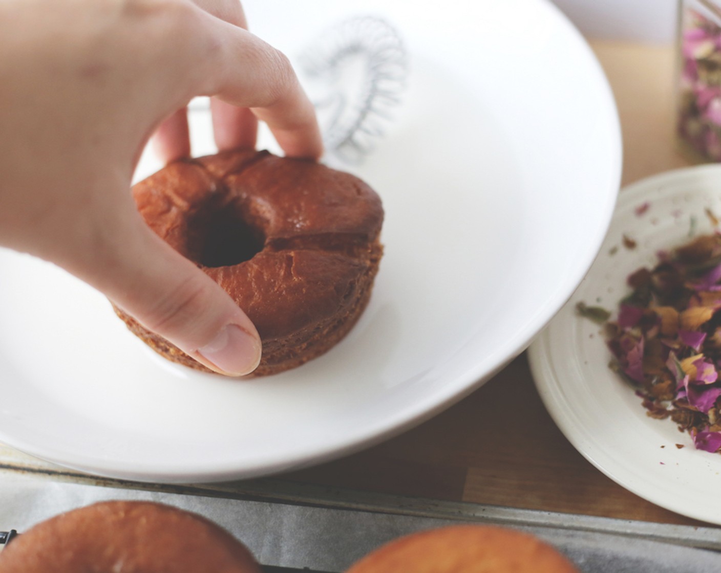 step 22 Dip one side of each doughnut into the glaze, topping with dried rose petals and unsalted shelled pistachios.