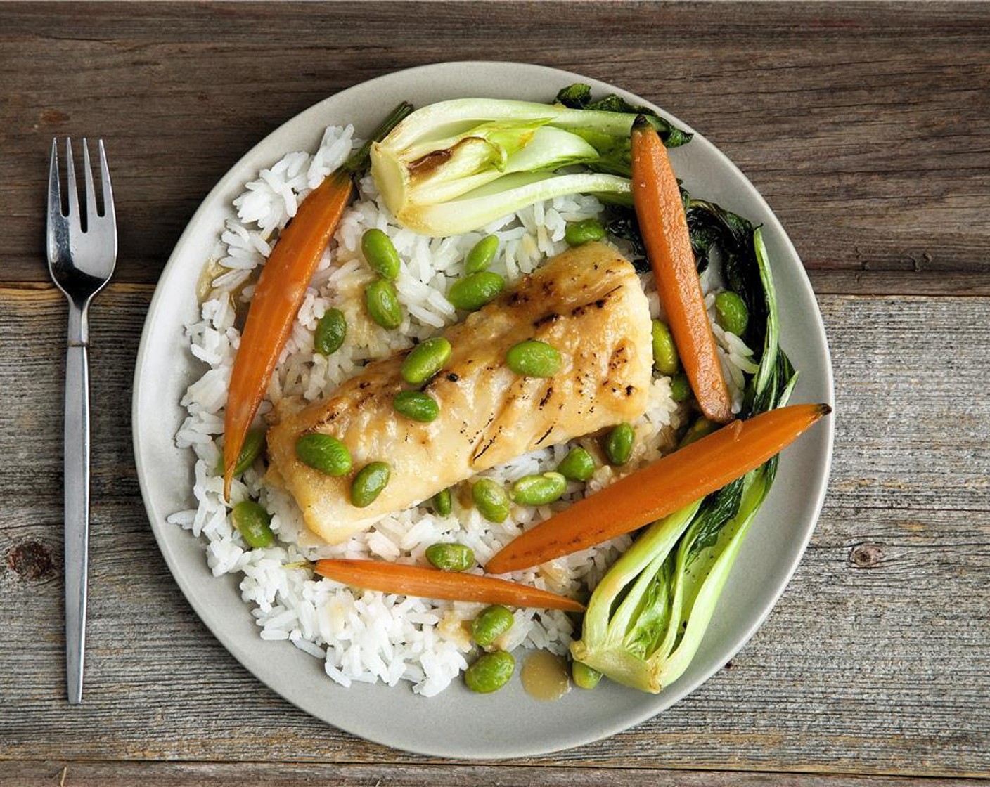 step 9 Divide the Jasmine Rice (2/3 cup) between two plates. Lay a piece of cod over the rice. Place vegetables around the rice.