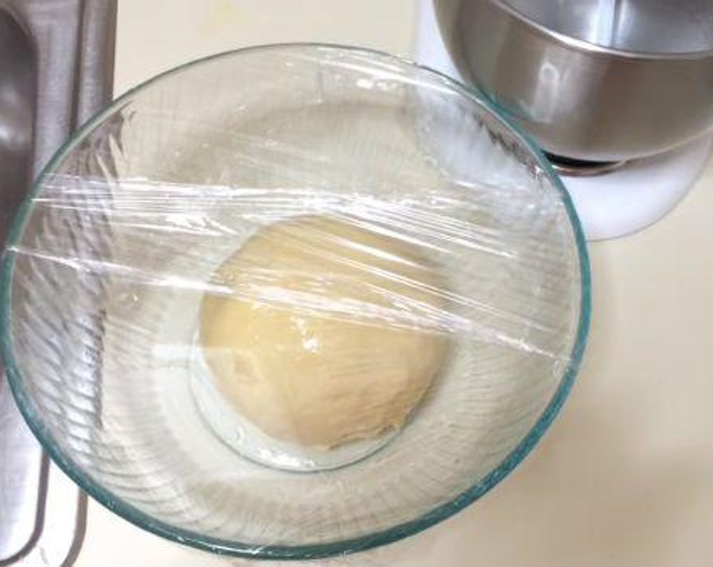 step 3 Take your dough, form it into a ball shape and place it into a greased bowl. Cover it with a plastic wrap, and place it in a warm place for about 2 hours.