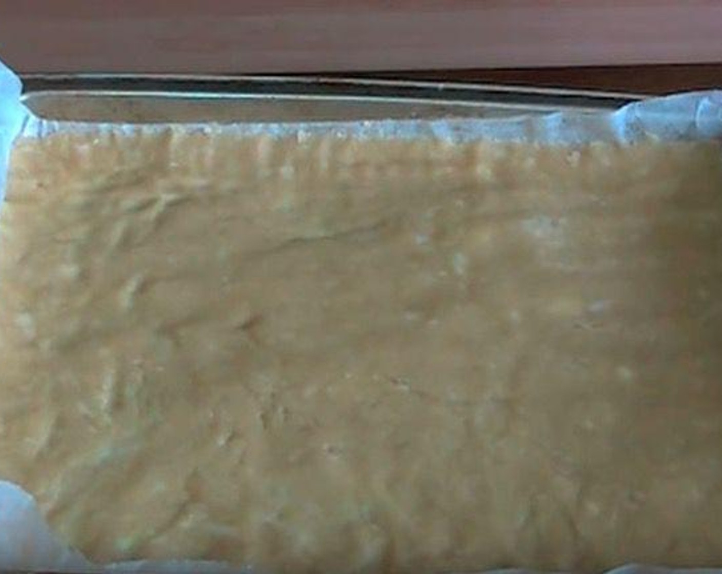 step 3 Press dough into the bottom of a lightly greased 18x28-centimeter pan lined with parchment paper.