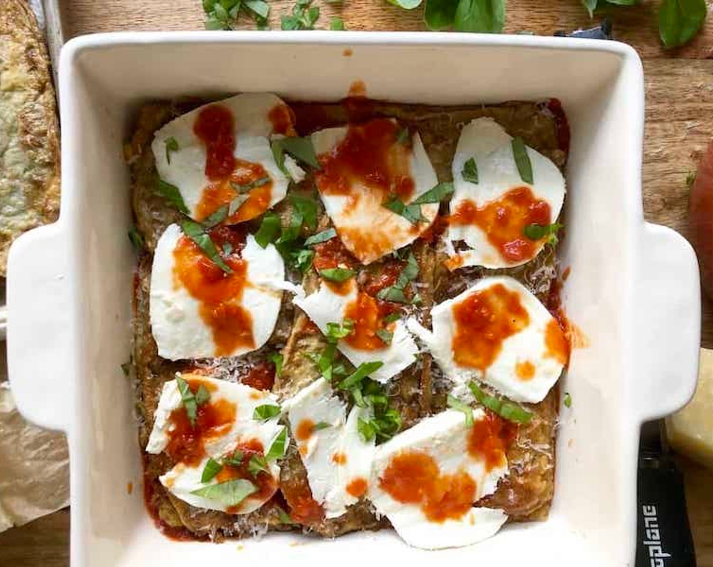 step 11 Place a layer of slightly overlapping eggplant slices, followed by a sparse coating of Mozzarella Cheese (4 cups) and a generous sprinkling of Parmigiano-Reggiano (1/2 cup) followed by approximately a 1/3 cup of marinara sauce along with some Fresh Basil Leaves (4 Tbsp).