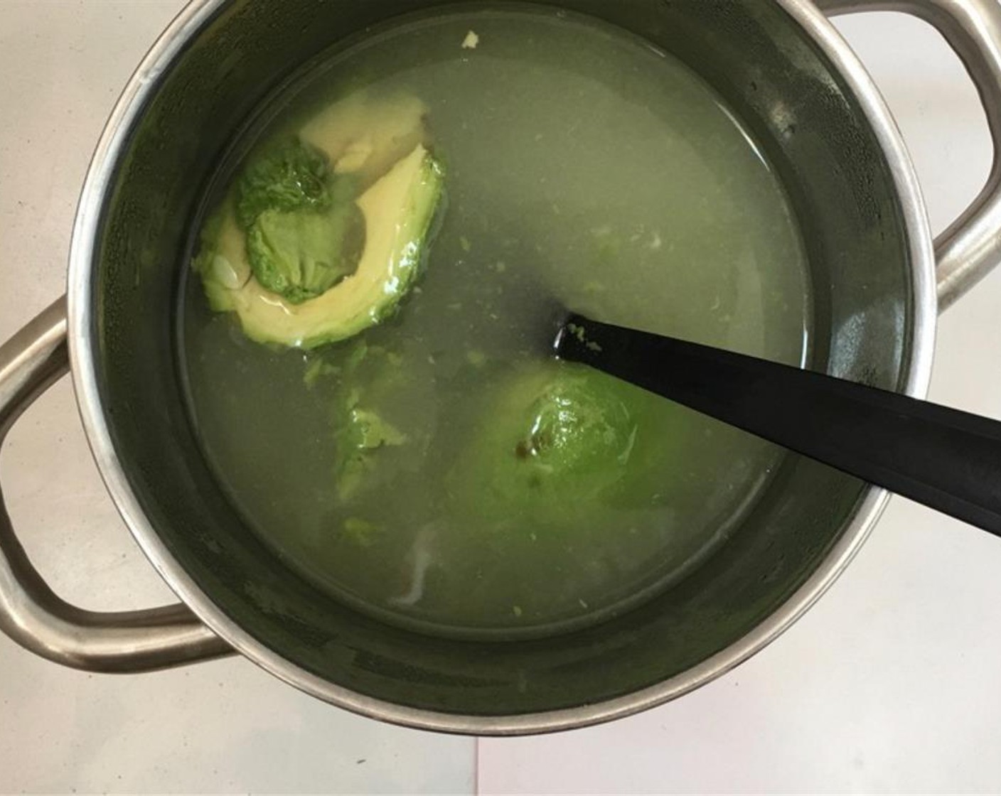 step 4 Place the chicken stock back over medium-high heat and bring it to a simmer. Slice the Avocado (1) in half, remove the seed and scoop the soft avocado meat out of its skin. Add it to the chicken stock. Season with Salt (to taste) and Ground Black Pepper (to taste).