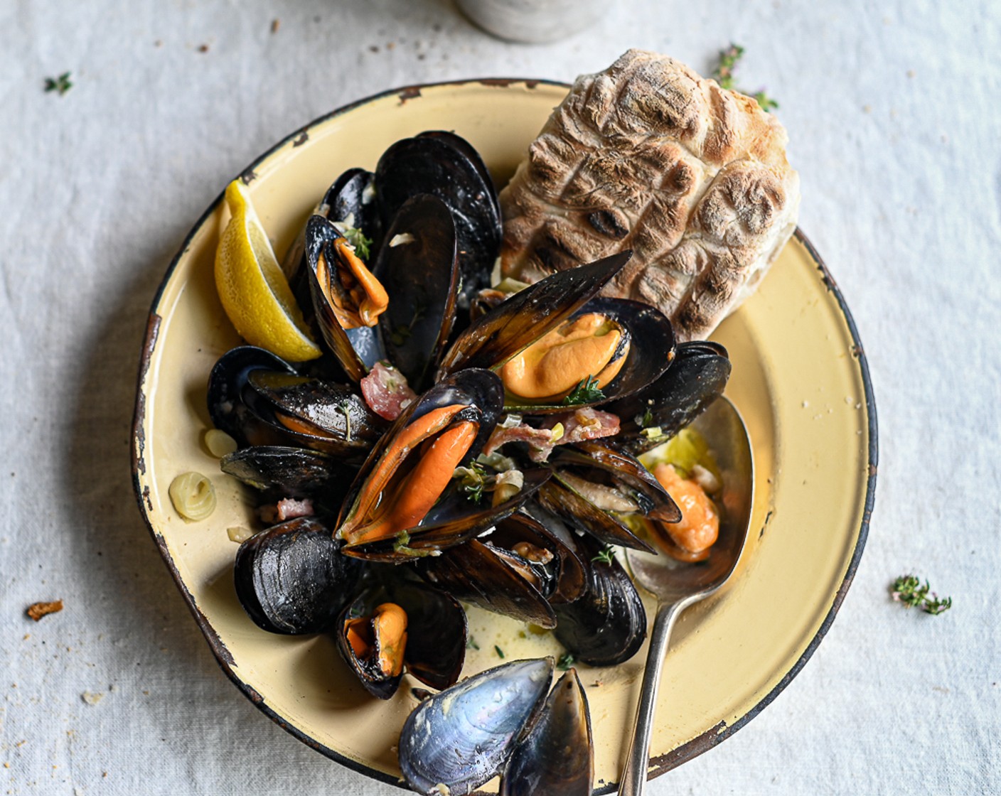 step 9 Stir the mussels through the sauce and divide between four warmed bowls. Serve immediately with a squeeze of Lemon (1) on the top and the warm roosterkoek to mop up the sauce.