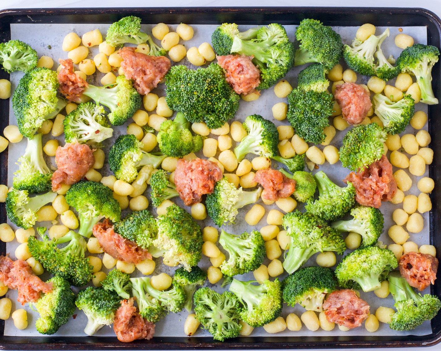 step 3 Spread the gnocchi mixture out on the sheet pan in an even layer (Use two sheet pans if necessary to avoid crowding). Remove the Ground Italian Sausage (1 lb) meat from the casings. Arrange the sausage meat in large chunks around the sheet pan. Season with Kosher Salt (1 tsp).