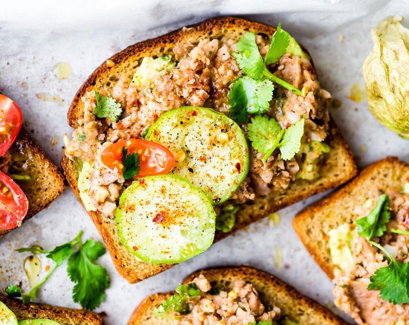 step 5 Add 1-2 tbsp of Avocado (1) on toast. The spread 2-3 tbsp of your mashed bean mix on top. Place a few slices of Tomatillo (1) on top of each bread along with Cherry Tomato (1/3 cup).