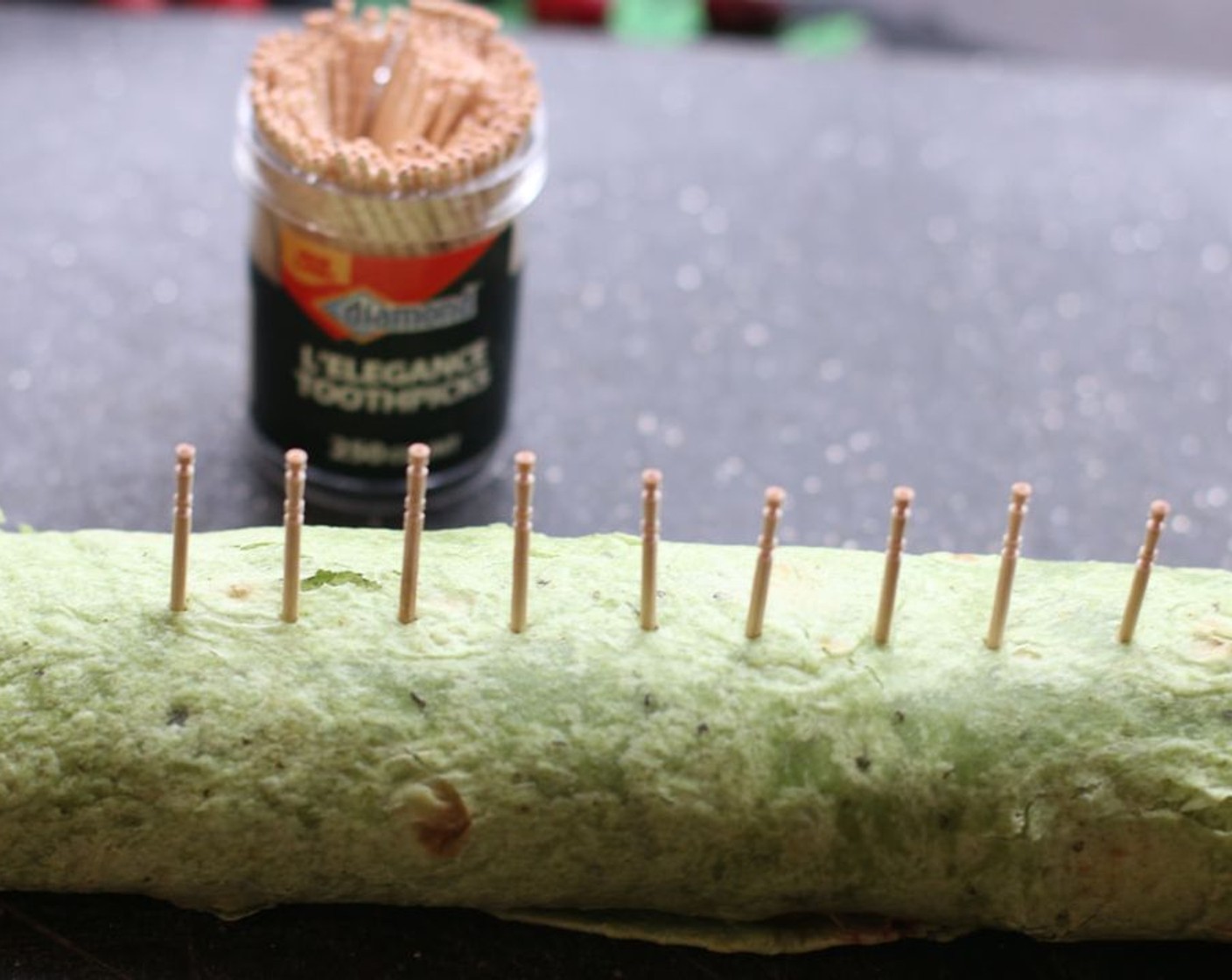 step 7 When ready to serve, remove plastic wrap. Insert toothpicks evenly about an inch apart from each other along the length of the rollup. Using a serrated knife, cut 1-inch pieces.