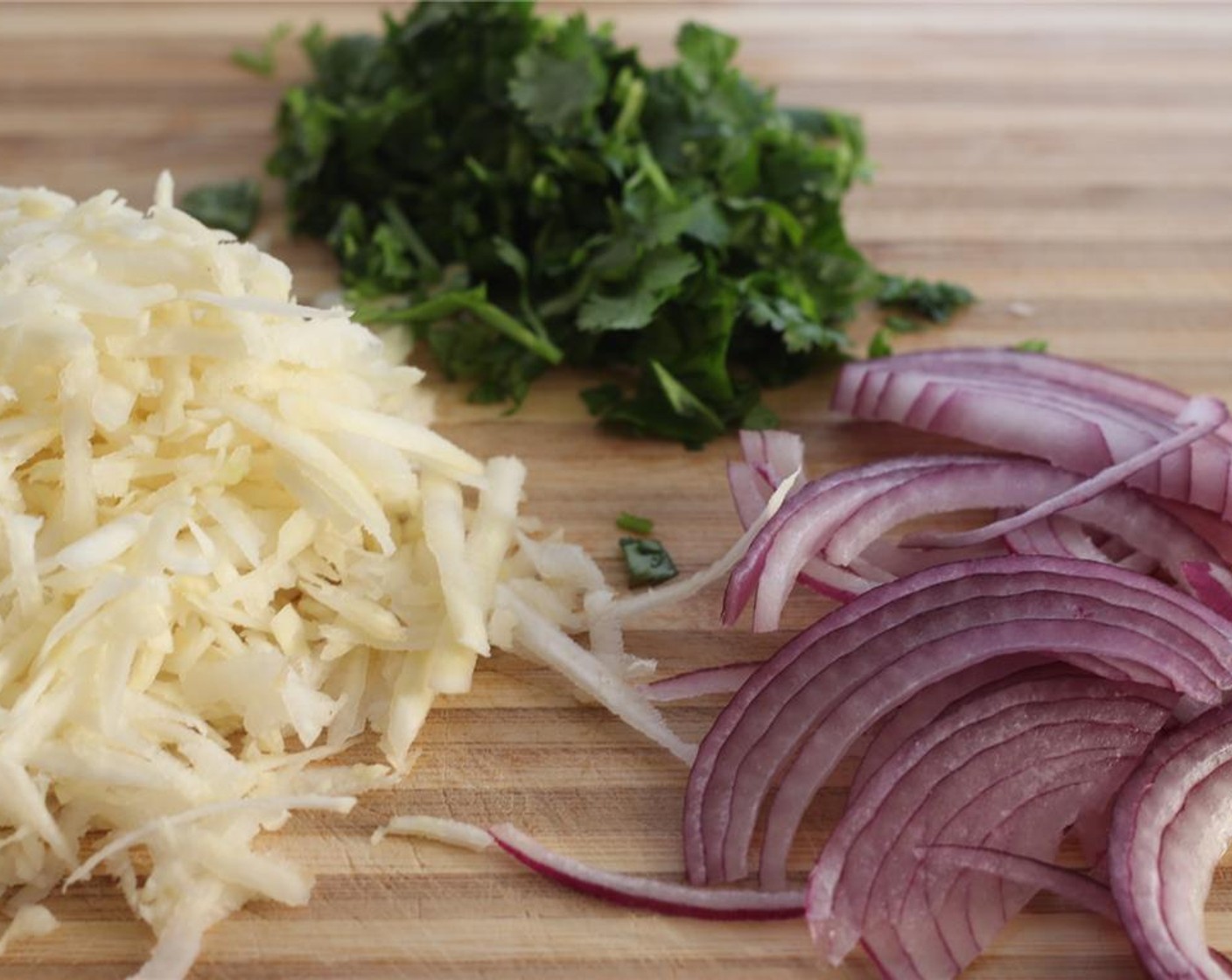 step 8 Peel the Kohlrabi (2) and remove the white outside, then grate. Slice the Red Onion (1/2) and chop the Fresh Cilantro (1/2 cup).