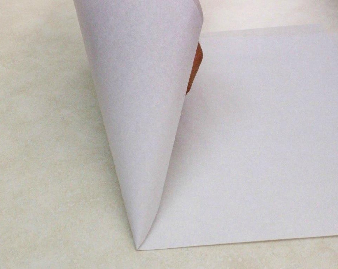 step 18 Make a pastry bag from parchment paper or regular printer paper, by taking the edges of the paper and bringing them together to form a thin point.